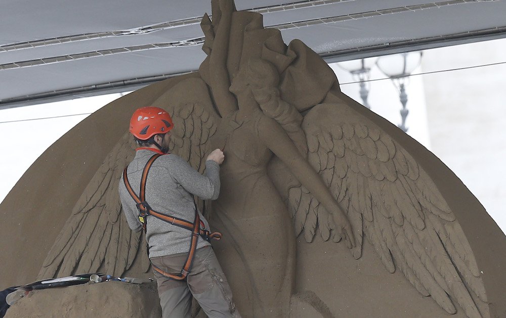A worker sculpts an angel on a Nativity scene made entirely of sand in St. Peter's Square at the Vatican Nov. 26. The 52-foot wide sculpture is made of sand from Jesolo