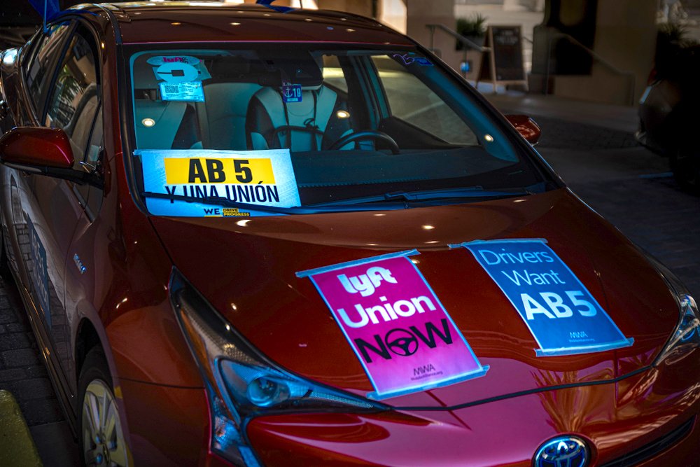 Car in Sacramento with Uber and Lyft signs displaying fliers advocating for legislative members to vote yes on Assembly Bill 5, to unionize the gig economy. (Philip Rozenski/Shutterstock)
