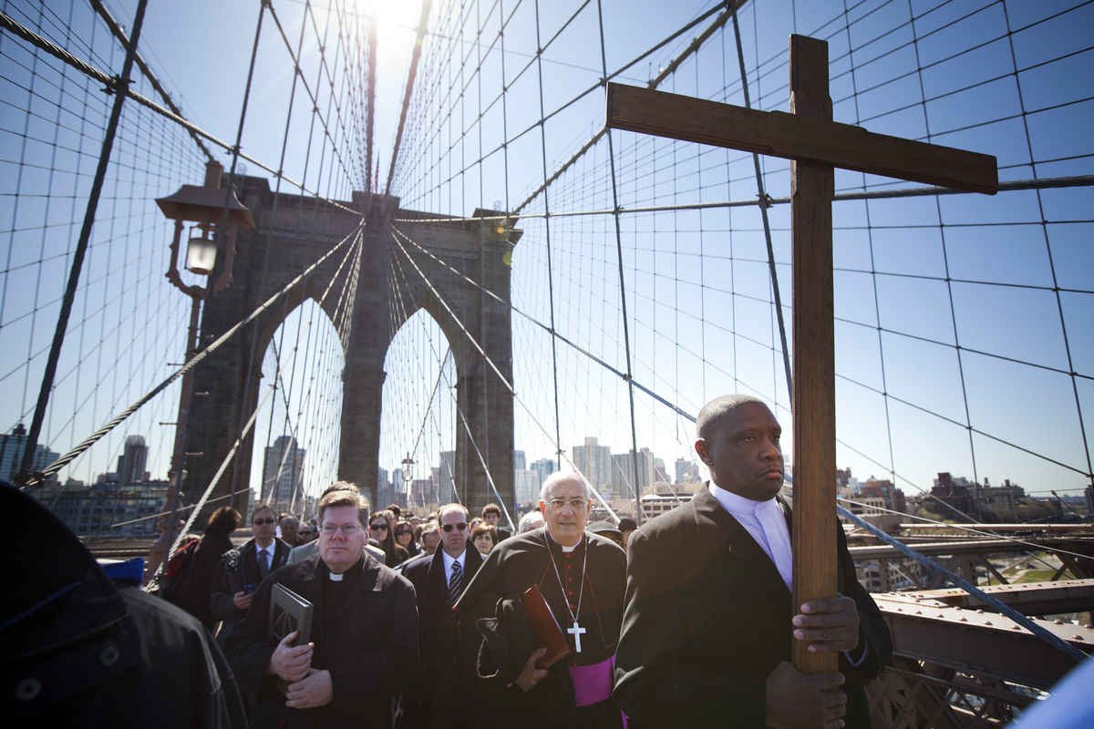 Worshippers lead by Rev. Richard Veras (L), Pastor at St Rita's Parish in Staten Island, The Most Rev. Nicholas DiMarzio (C), Bishop of Brooklyn, and Frank Simmonds (R), leader of New York Community of Communion & Liberation, march over the Brooklyn Bridge in the 17th Way Of The Cross procession on April 06, 2012 in New York City. MICHAEL NAGLE/GETTY IMAGES