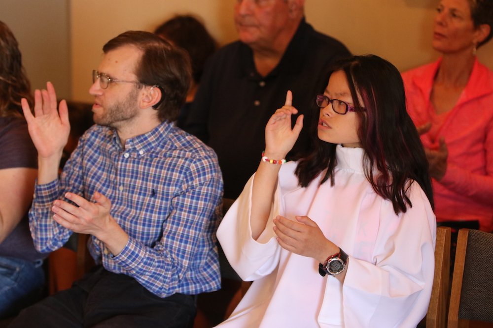 Christopher Sloan and Sophia Jo Peters sign the creed during a Mass in sign language in early September in the chapel at St. Peter Parish in Portland
