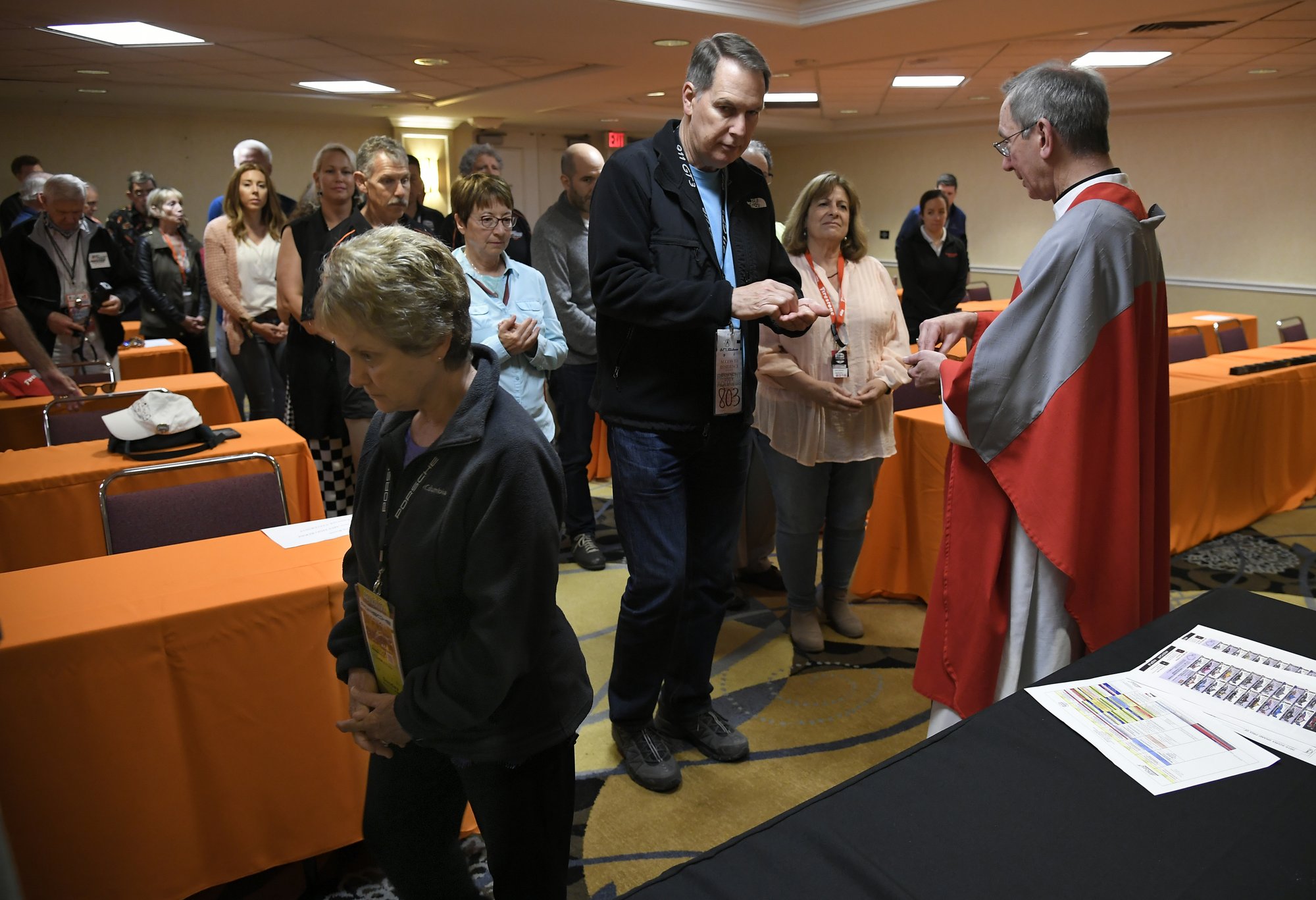 Bishop Marc Trudeau distributes communion at a special Mass for crew members at the Long Beach Grand Prix. (JOHN MCCOY)