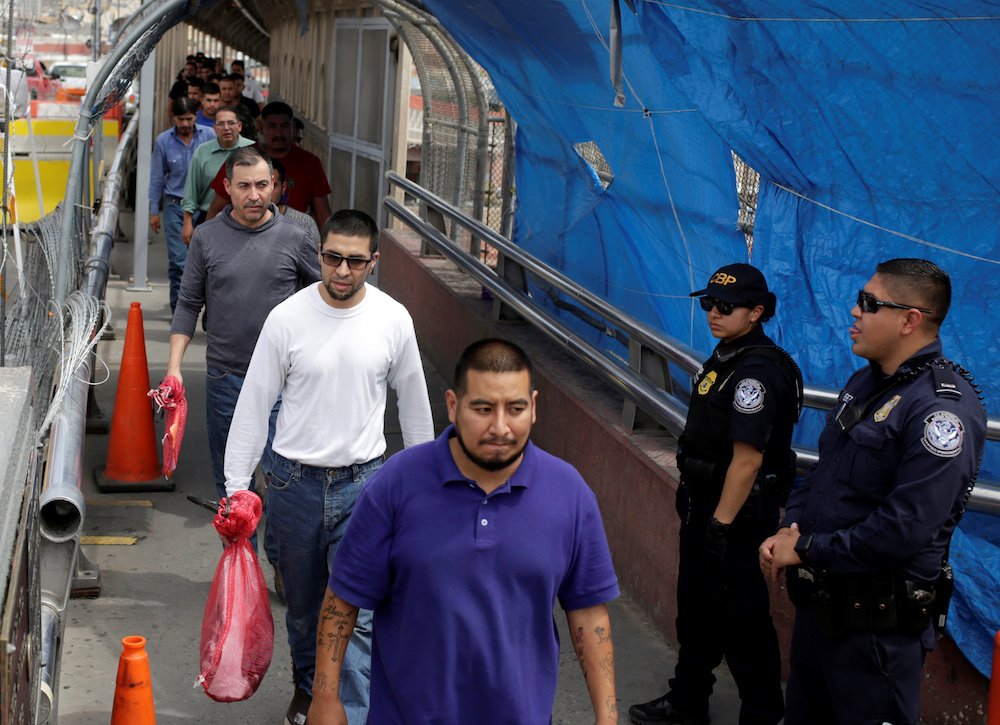 Mexican migrants deported from the U.S. walk toward Mexico at Paso del Norte International border bridge in this July 17