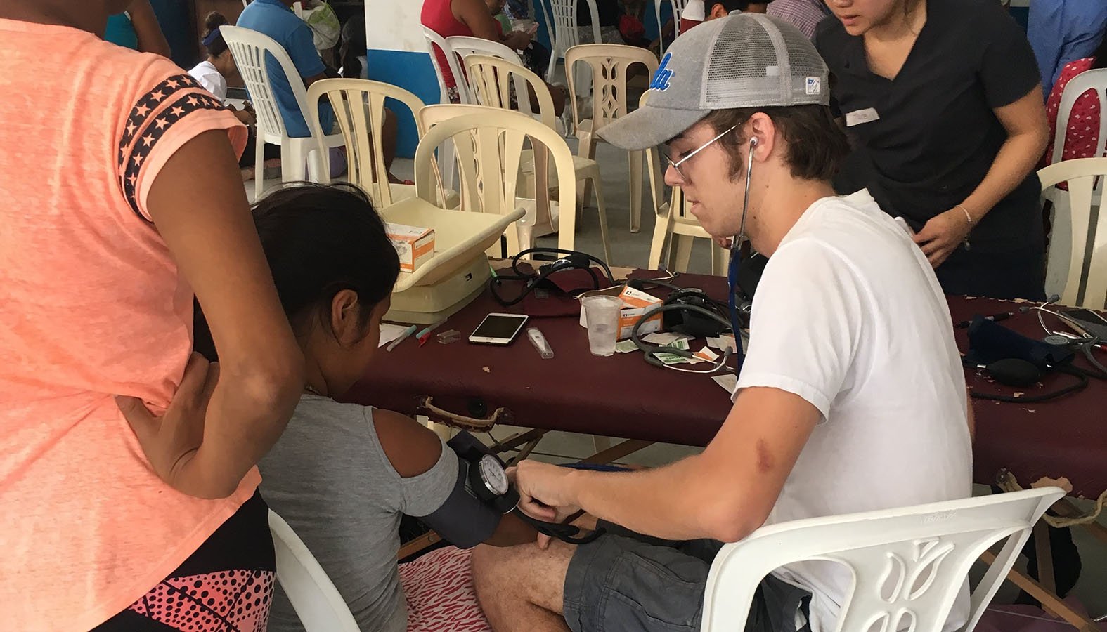 Ryan Clydesdale, a student at the University of California Los Angeles and a missionary with the Fellowship of Catholic University Students, checks a child's vital signs at a clinic during a spring break trip serving the people in Pamplona, Peru. (CNS photo/courtesy FOCUS)
