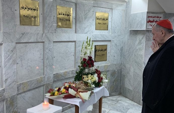 Cardinal Pietro Parolin, Vatican secretary of state, pauses in prayer before the tombs of priests killed during a terrorist attack in 2010 in the Syriac Catholic Cathedral of Our Lady of Deliverance in Baghdad. The cardinal was visiting Iraq Dec. 24-28. (CNS photo/Vatican Media/file via Crux)