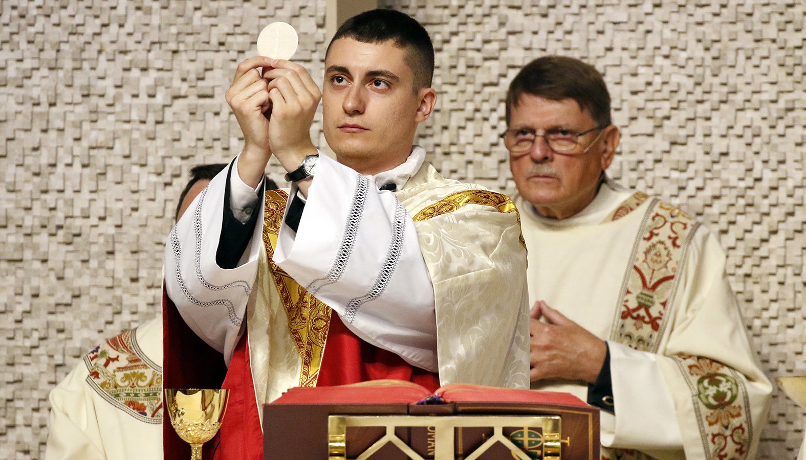 Father Cody Bobick elevates the Eucharist as he celebrates his first Mass as a newly ordained priest June 23, 2019, the feast of Corpus Christi, at St. Frances de Chantal Church in Wantagh, N.Y. (CNS photo/Gregory A. Shemitz)