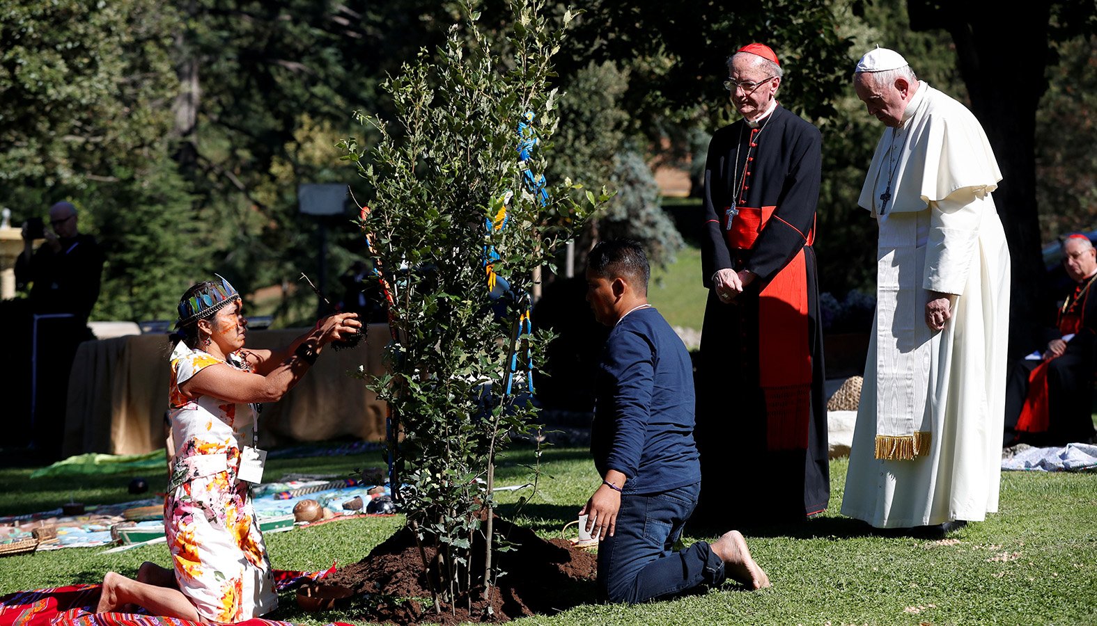 Pope Francis and Brazilian Cardinal Claudio Hummes, relator general of the Synod of Bishops on the Amazon, watch as members of an indigenous community plant a tree during a celebration marking the feast of St. Francis in the Vatican Gardens Oct. 4, 2019. (CNS photo/Yara Nardi, Reuters)