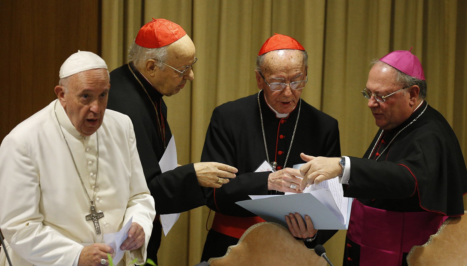 Pope Francis is pictured as Cardinal Lorenzo Baldisseri, secretary-general of the Synod of Bishops, Brazilian Cardinal Claudio Hummes, relator general of the synod, and Bishop Fabio Fabene, undersecretary of the Synod of Bishops, talk at the start of the final session of the Synod of Bishops for the Amazon at the Vatican Oct. 26, 2019. (CNS photo/Paul Haring)