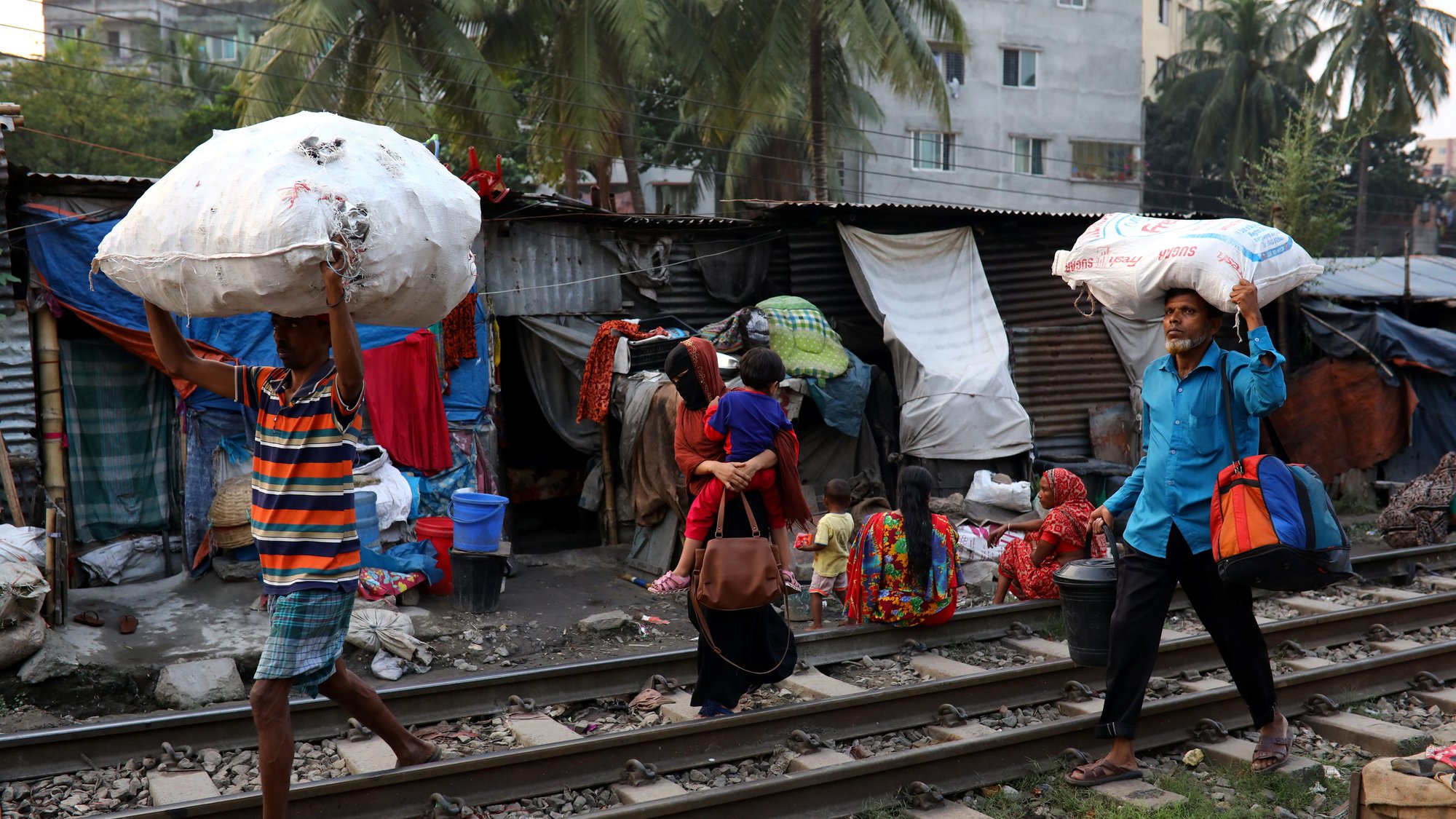 People in Dhaka, Bangladesh, walk along a railroad with their belongings Oct. 30, 2019. Catholic faithful in the Archdiocese of Chittagong, Bangladesh, paid tribute Nov. 14 to 17th-century Christian missionaries and martyrs during a Mass and blessing of a memorial dedicated to their memory. (CNS photo/Mohammad Ponir Hossain, Reuters)