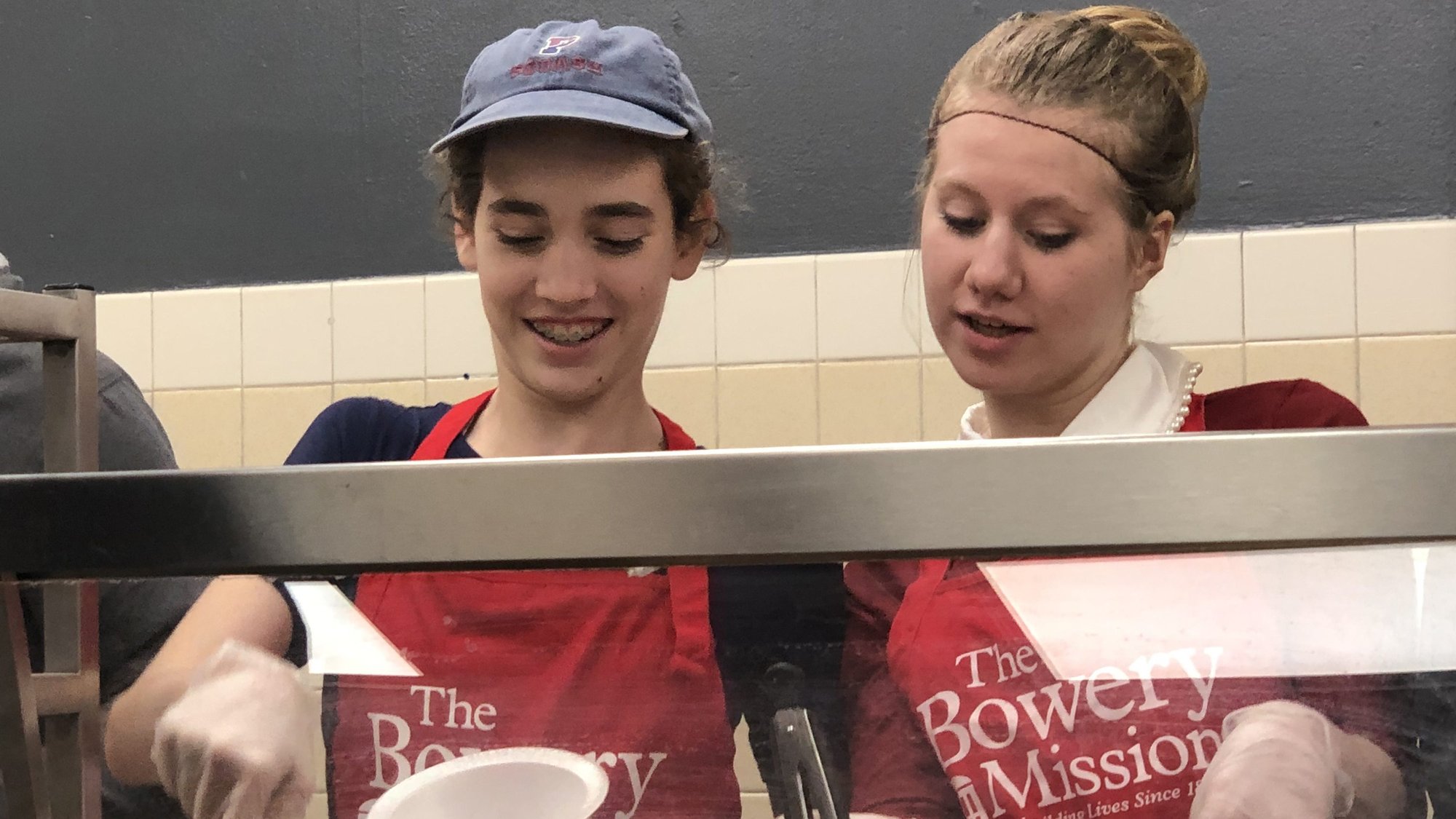 Members of the Warriors, a youth-led service group from the Basilica of St. Patrick's Old Cathedral in New York City, are pictured serving dinner earlier this year at the Bowery Mission, which provides food for those in need in New York City. Working with these young people is a personal calling for Jeannie Gaffigan, co-writer and producer of comedy specials, two books and a television series with her husband and business partner, Jim Gaffigan. (CNS photo/courtesy Warriors youth group)