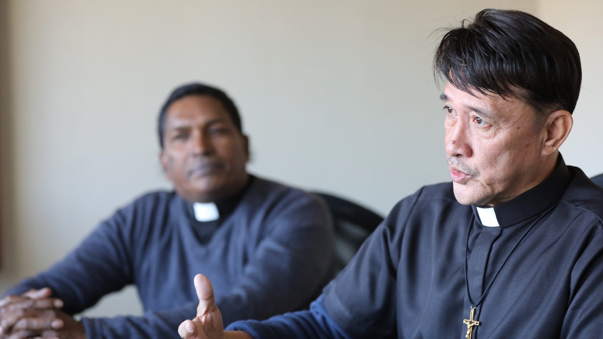 Franciscan Father Neville Fernando of Negombo, Sri Lanka, listens as Oblate Oblate Father Romeo Saniel, apostolic administrator of the Vicariate of Jolo, Philippines, speaks during a Nov. 21, 2019, interview in Washington. Father Fernando has participated in several rounds of peace negotiations between the Philippine government and Muslim factions. (CNS photo/Bob Roller)