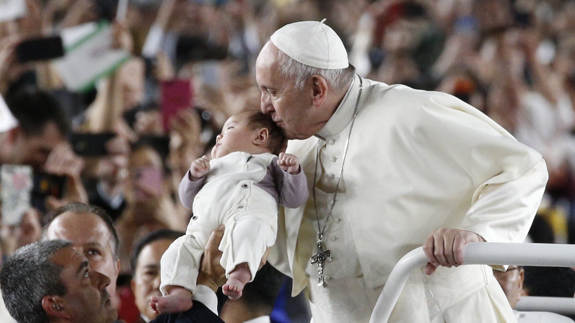Pope Francis kisses a baby before celebrating Mass in Tokyo Dome in Tokyo Nov. 25, 2019. (CNS photo/Paul Haring)