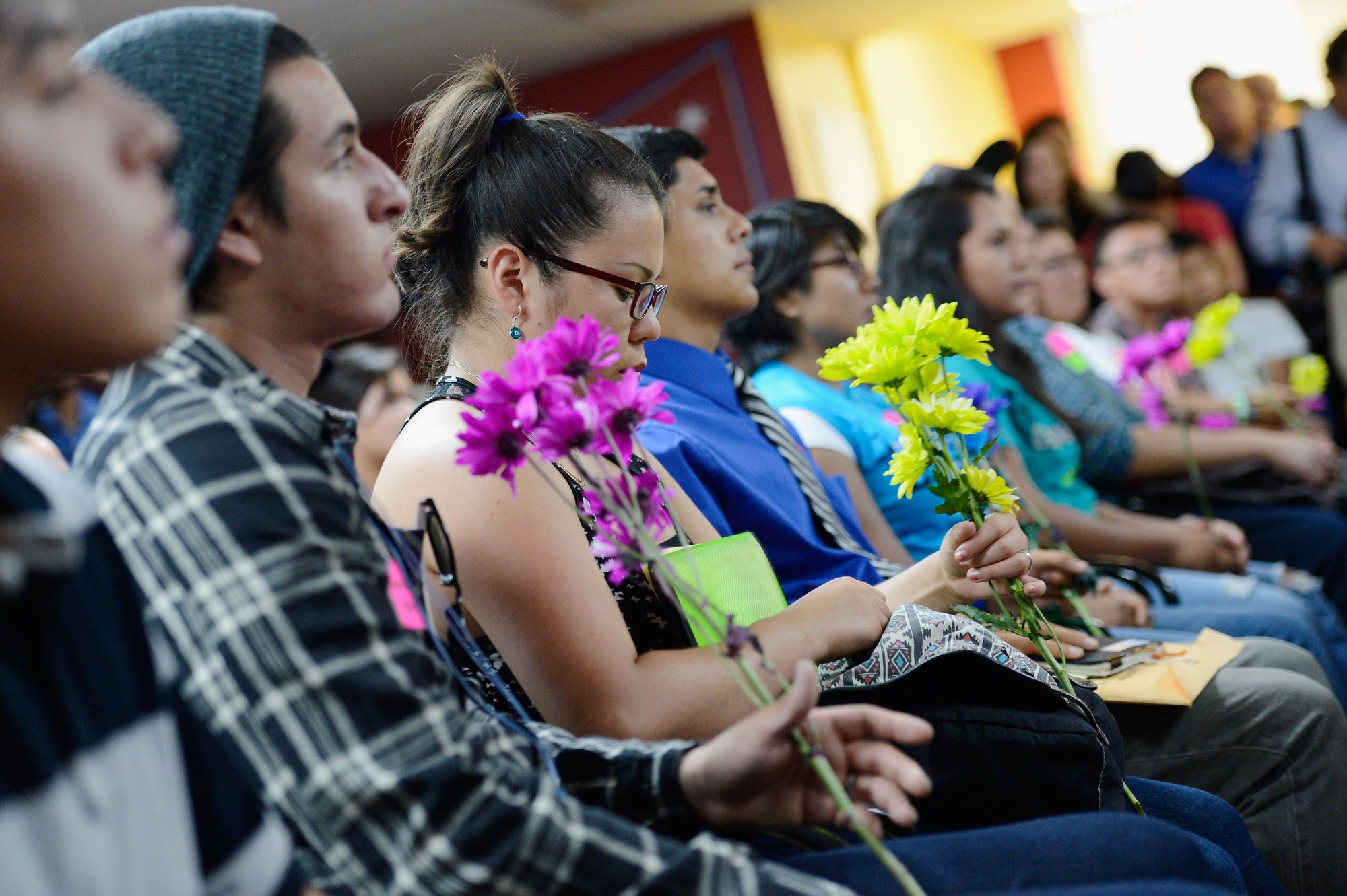 A group of "DREAMers" hold flowers at a news conference kicking off the Deferred Action for Childhood Arrivals program on August 15, 2012 in Los Angeles, California. (KEVORK DJANSEZIAN/GETTY IMAGES)