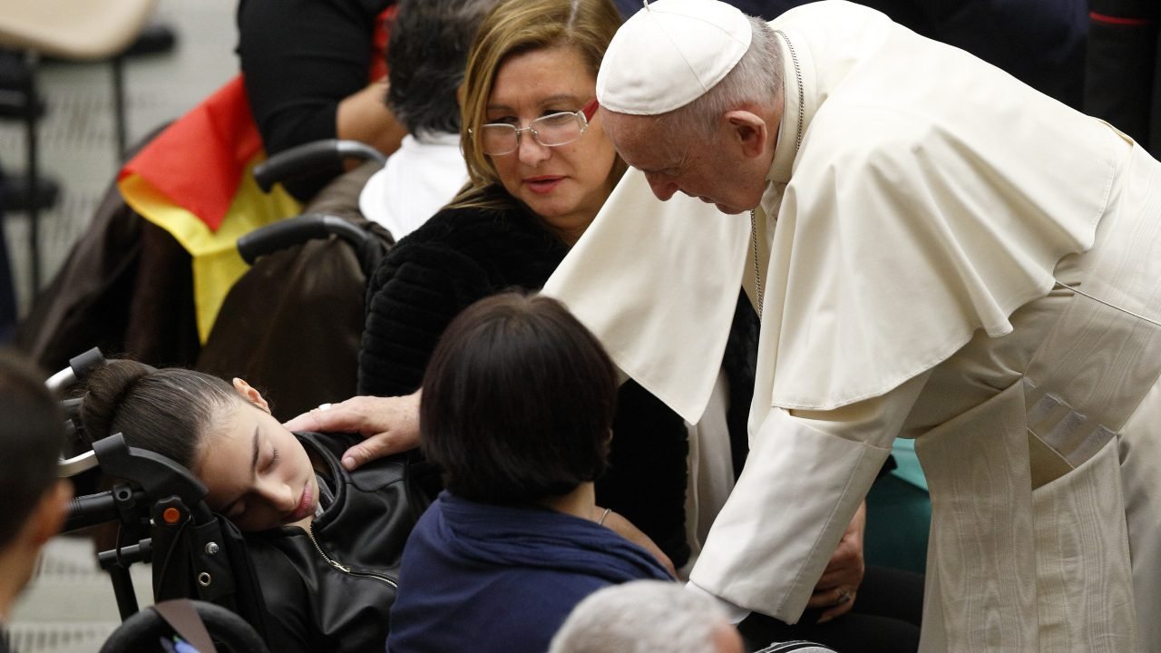 Pope Francis greets a sleeping girl as he meets the disabled during his general audience in Paul VI hall at the Vatican. (CNS photo/Paul Haring)