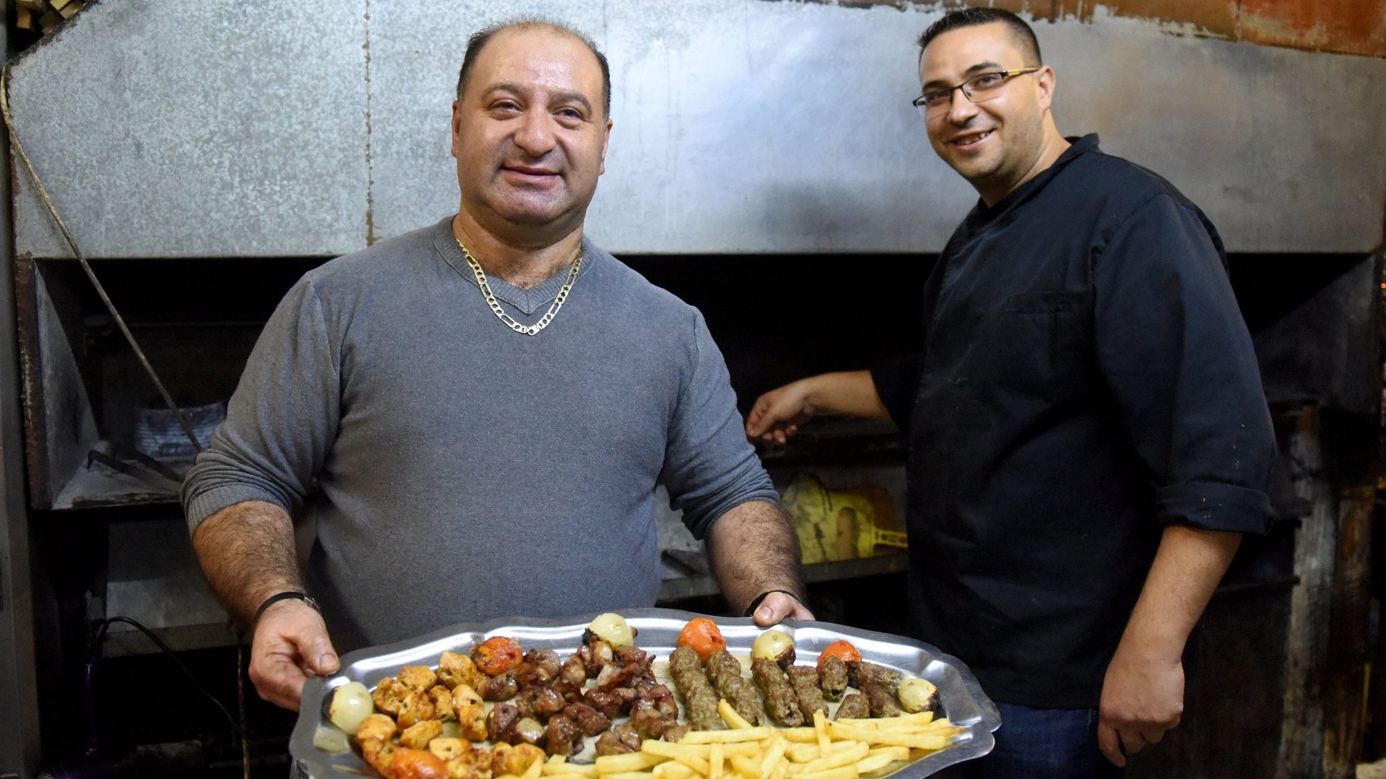 Palestinian Melkite Catholics Eli and Peter Hosh prepare meat in the kitchen of their restaurant, Abu Eli, in Bethlehem, West Bank, Dec. 8, 2019. (CNS photo/Debbie Hill)