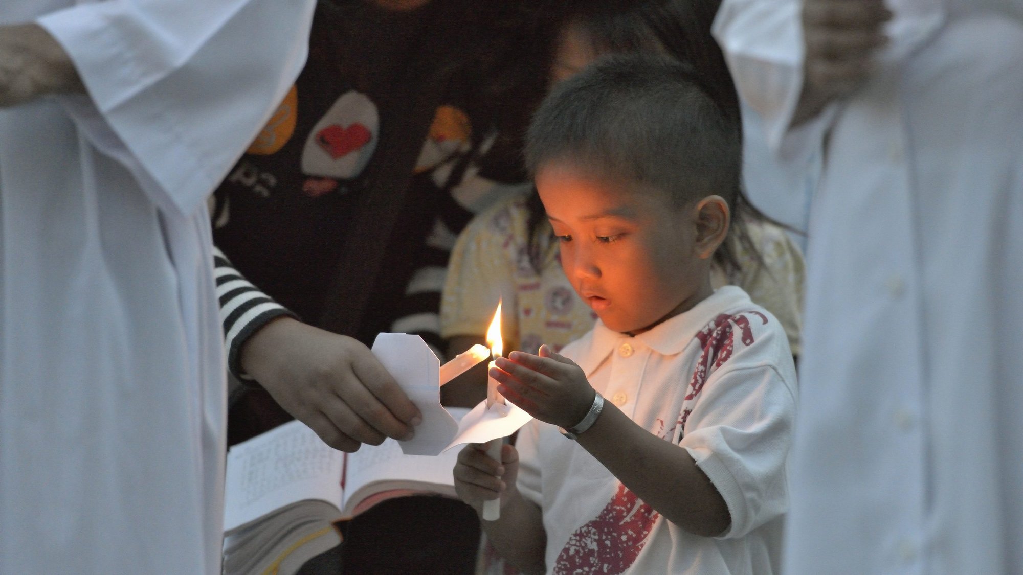 People light candles at the beginning of a 2014 Mass at Sacred Heart Catholic Church in Banda Aceh, Indonesia. The Indonesian bishops will take steps to address claims in a Catholic media report that dozens of people have been abused in Catholic institutions across the country, said a bishops' conference official. (CNS photo/ Paul Jeffrey)