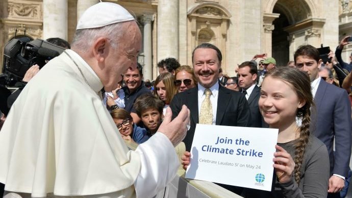 Swedish teenage environmental activist Greta Thunberg holds up a sign as Pope Francis greets her at the end of his weekly general audience, in St. Peter's Square, at the Vatican, Wednesday, April 17, 2019. (Vatican Media/AP via Crux))
