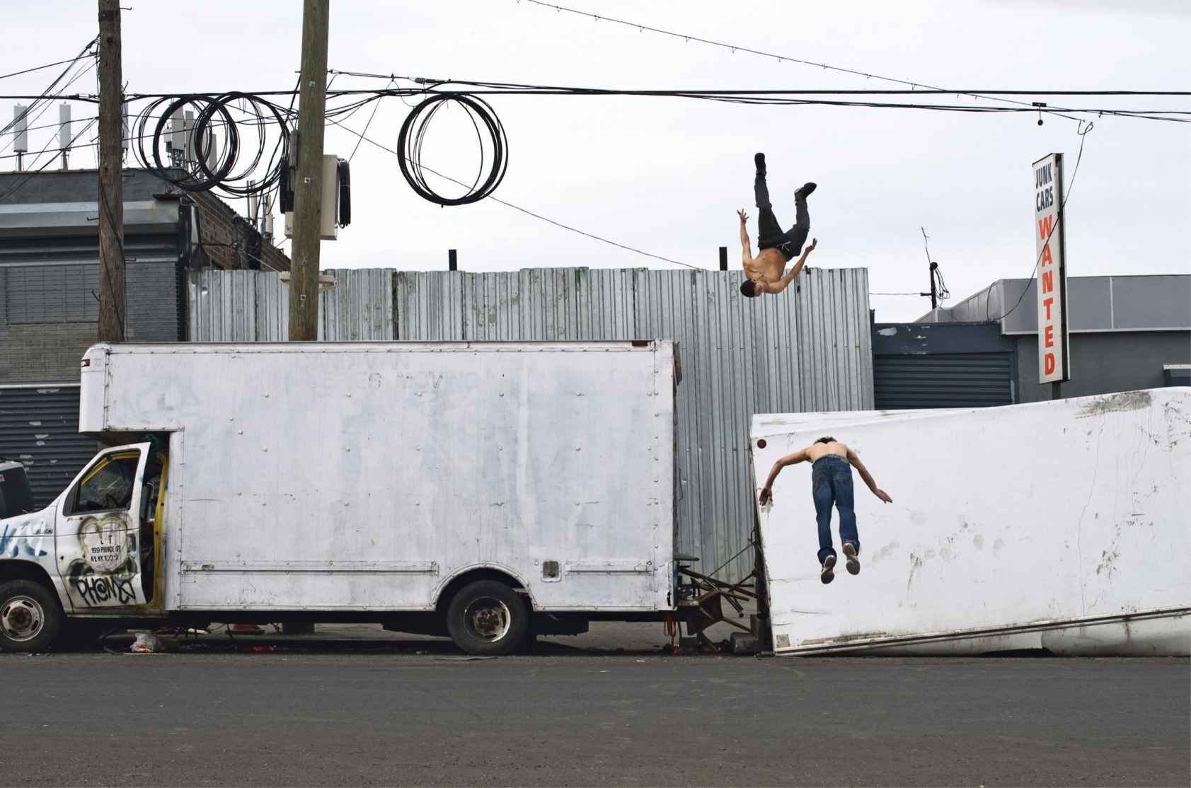 A photo from "Dignity" depicting two men who appear to be "flying" in Hunts Point, the Bronx. (Chris Arnade via Amazon)