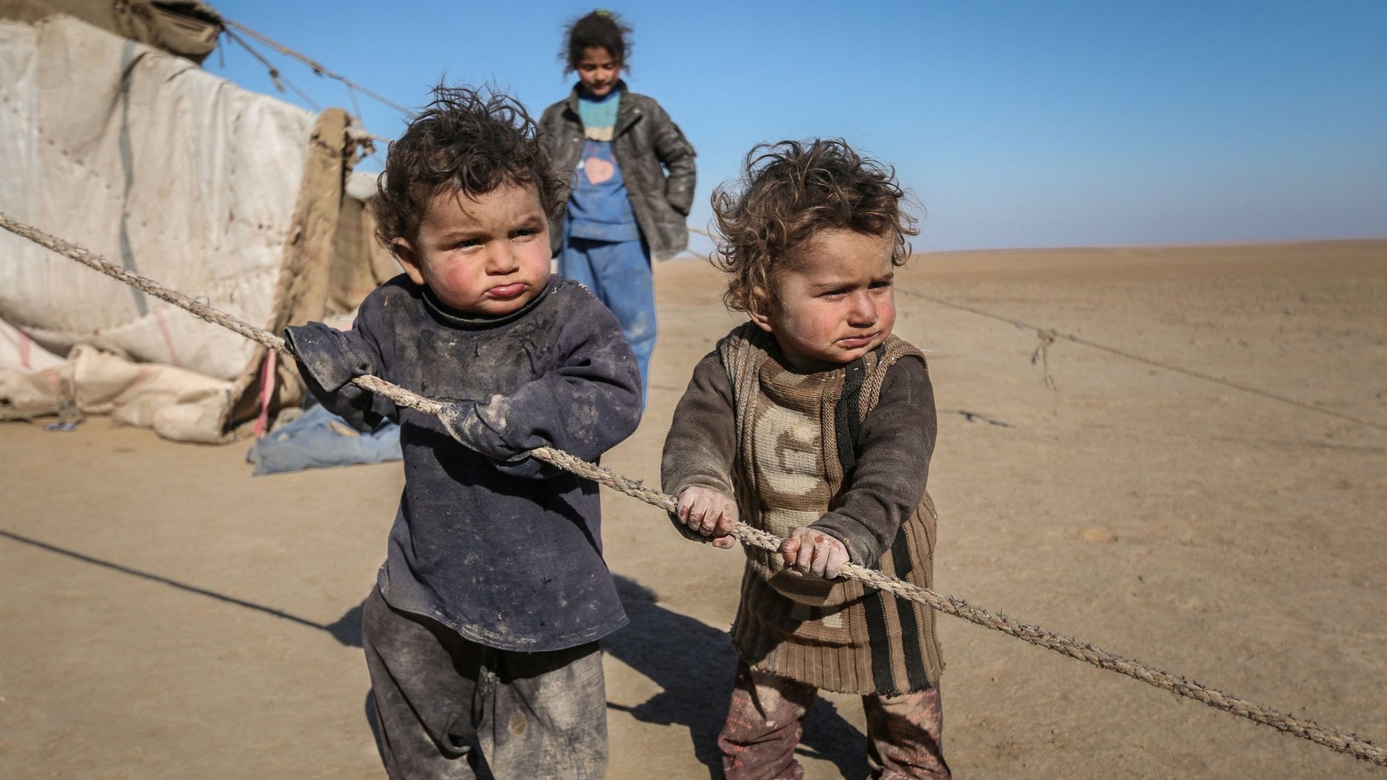 Internally displaced Syrian children who fled Raqqa city stand near their tent in Ras al-Ain, Syria, Jan. 22, 2017. Refugees make an important impact in the United States and should not be denied resettlement as the Texas governor recently decided, said Miami Archbishop Thomas G. Wenski. (CNS photo/Rodi Said, Reuters)