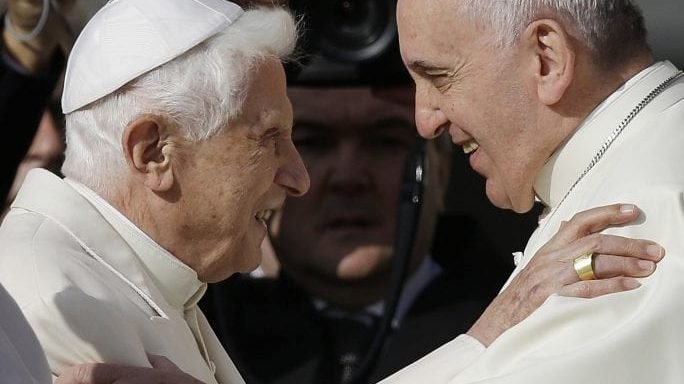 In this Sept. 28, 2014 file photo, Pope Francis, right, hugs Pope Benedict XVI prior to the start of a meeting with elderly faithful in St. Peter's Square at the Vatican. (Gregorio Borgia/AP via Crux)