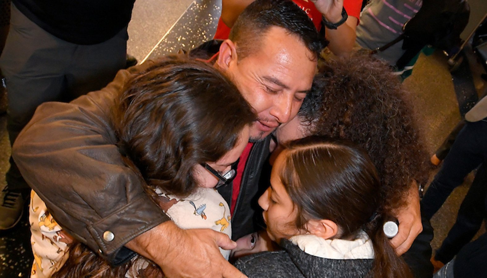 Fernando Arredondo embraces his daughters and wife at Los Angeles International Airport Jan. 22 after a year of separation. (John McCoy)