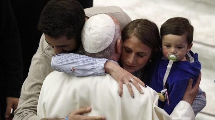 Pope Francis embraces a couple with a child at the end of his weekly general audience at the Vatican, Wednesday, Jan. 8, 2020. (Gregorio Borgia/AP via Crux)