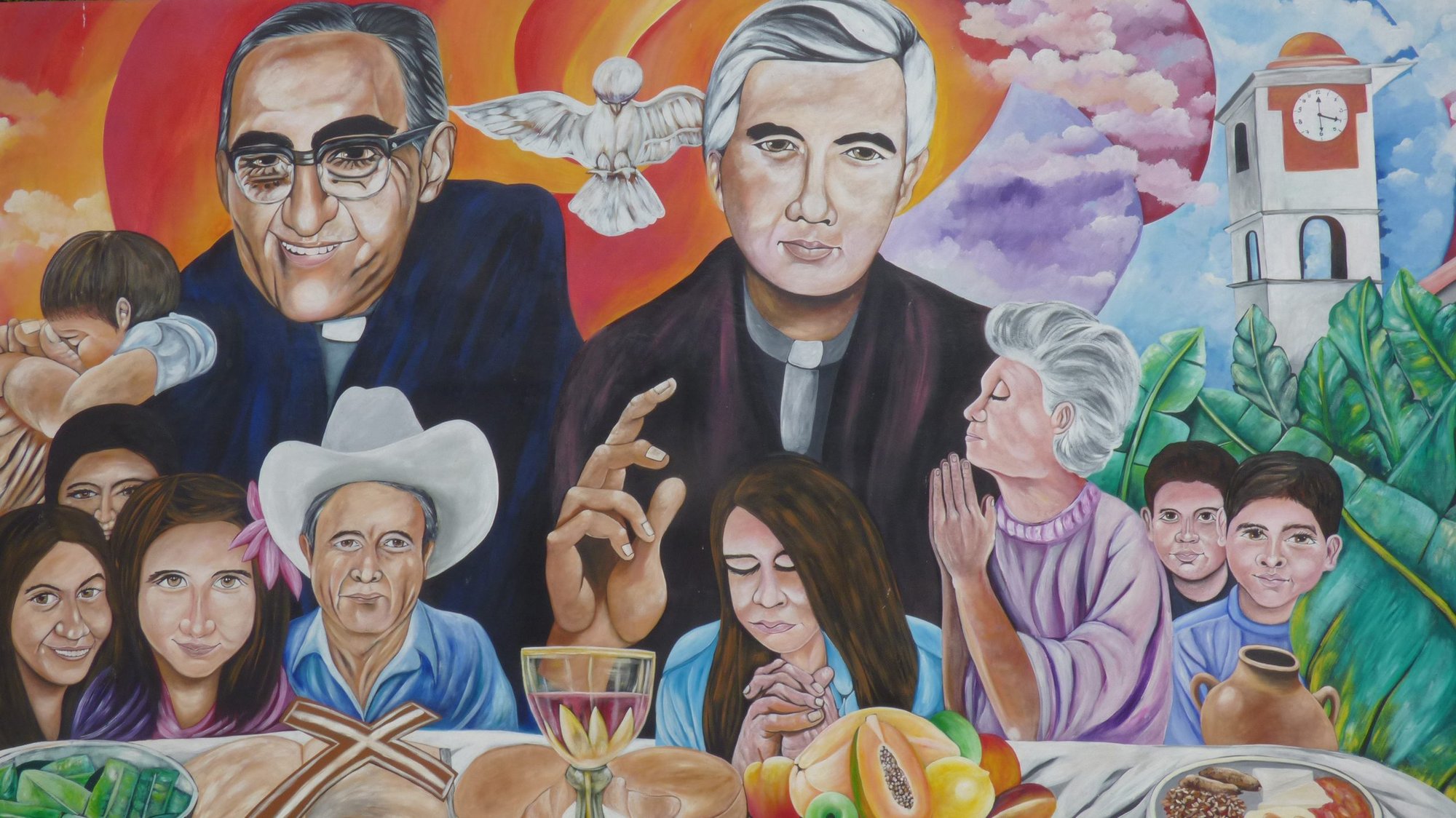 A mural in El Paisnal, El Salvador, seen in this Jan. 29 photo, features Blessed Oscar Romero and town native Father Rutilio Grande, surrounded by rural men, women and children, the community the Jesuit Father Grande served from 1972 until his March 12, 1977, assassination. Father Grande spoke of his dream of a communal table where everyone, including the poor, had a place to eat and a right to have a say in matters that affected them. (CNS photo/Rhina Guidos)