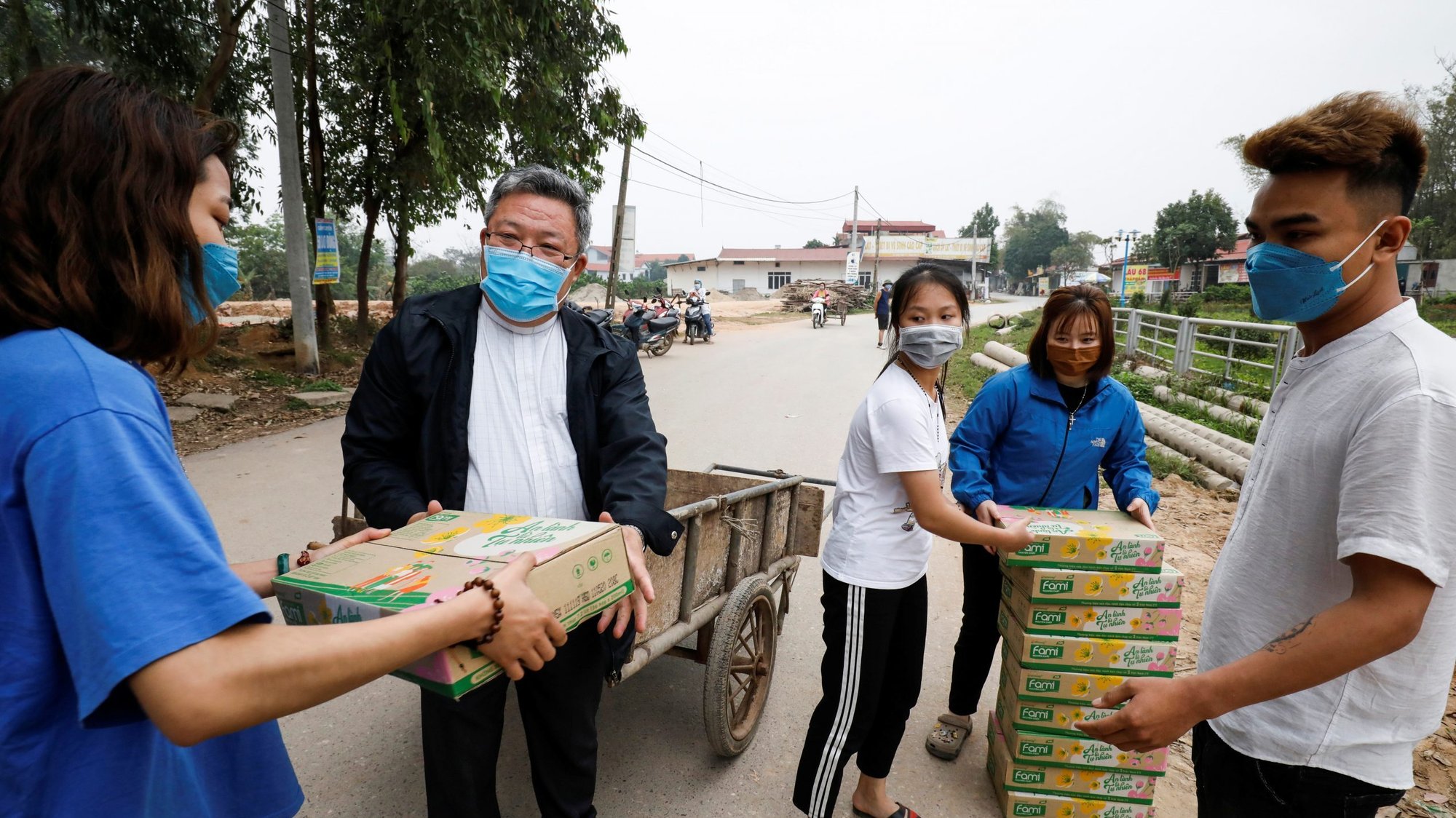 Father Francis Xavier Nguyen Duc Dai distributes food to local people while wearing a protective mask in Son Loi, Vietnam, Feb. 25, 2020. The area has been quarantined due to the coronavirus. (CNS photo/Kham, Reuters)