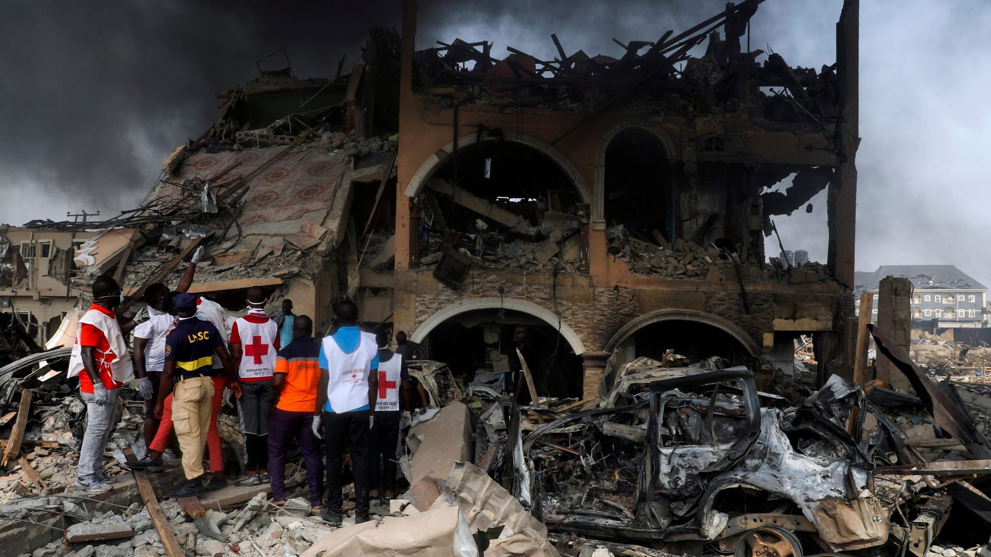 Paramedics and security in Lagos, Nigeria, observe a building that was damaged by a pipeline explosion March 15, 2020. Archbishop Adewale Martins confirmed March 16 that a nun and a female security guard died while rescuing students from a chapel that had caught fire. (CNS photo/Temilade Adelaja, Reuters)