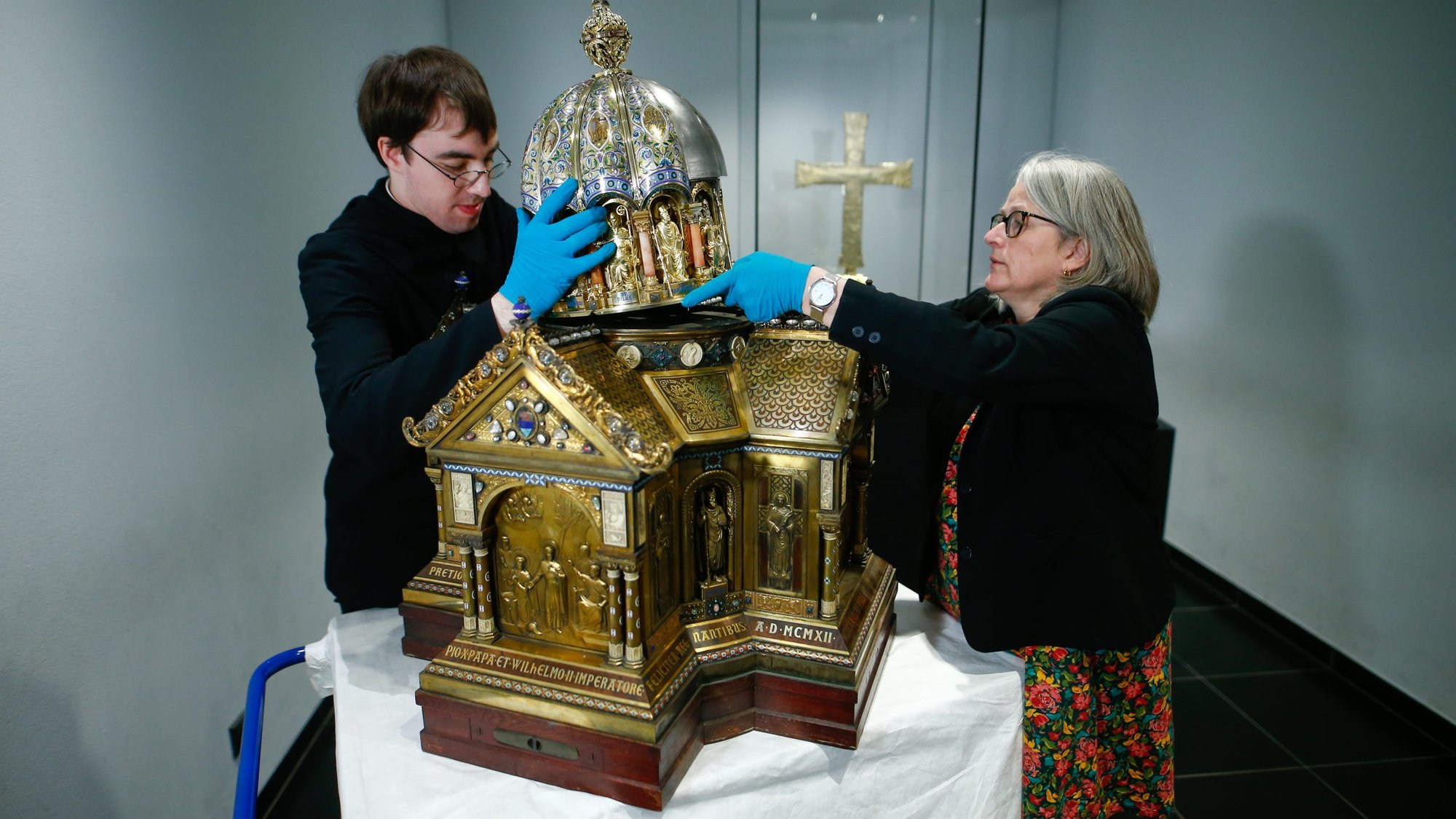 Restorer Luke Jonathan Koeppe and Birgitta Falk, an official of the cathedral in Aachen, Germany, assemble the shrine with the relics of St. Corona March 25, 2020. (CNS photo/Thilo Schmuelgen, Reuters)