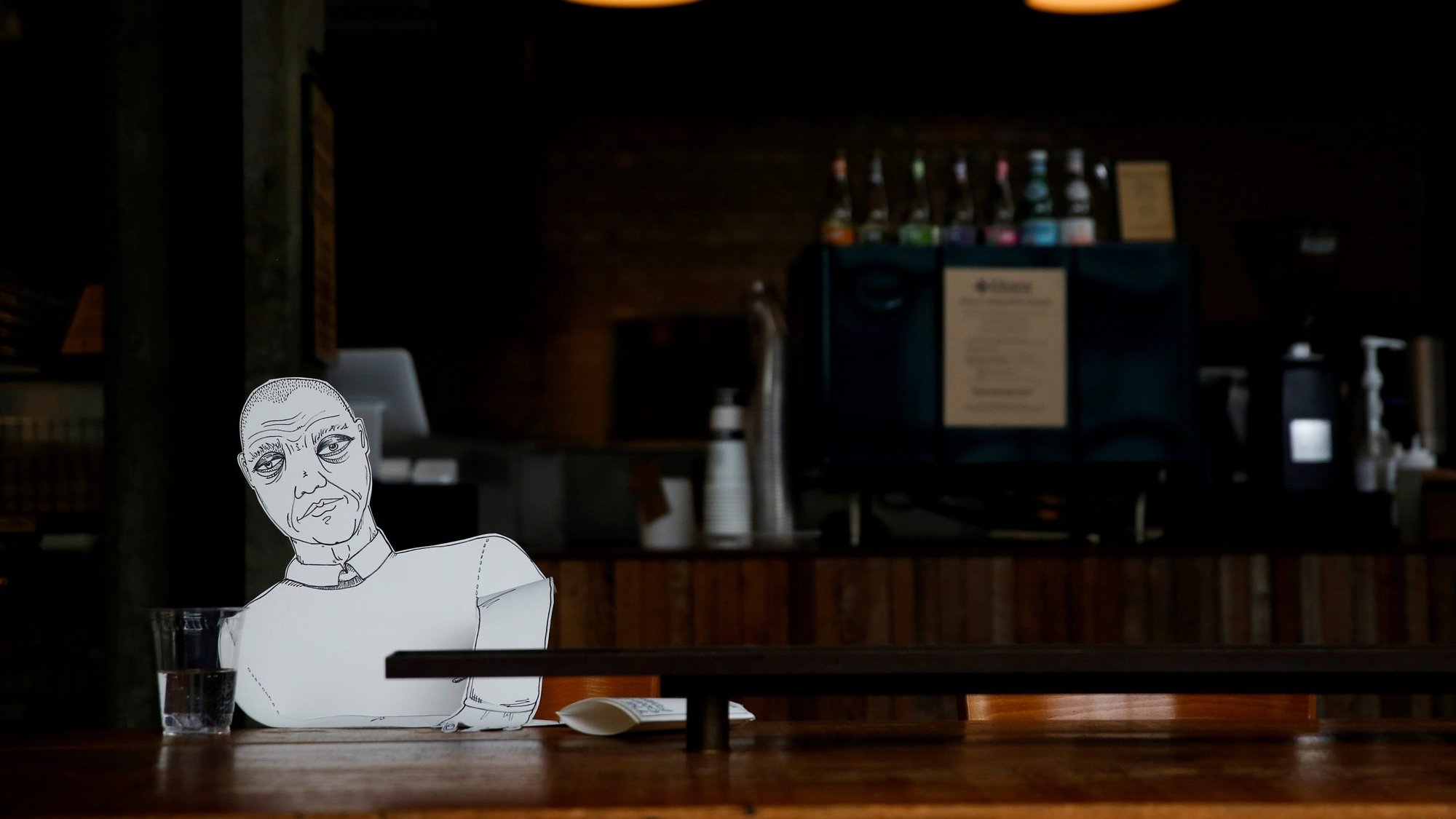 A paper cutout of a person sits at an empty table at a bagel cafe during the coronavirus pandemic in Seattle March 27, 2020. Outreach efforts by Catholic agencies continue in large part during the virus-mandated restrictions. (CNS photo/Lindsey Wasson, Reuters)