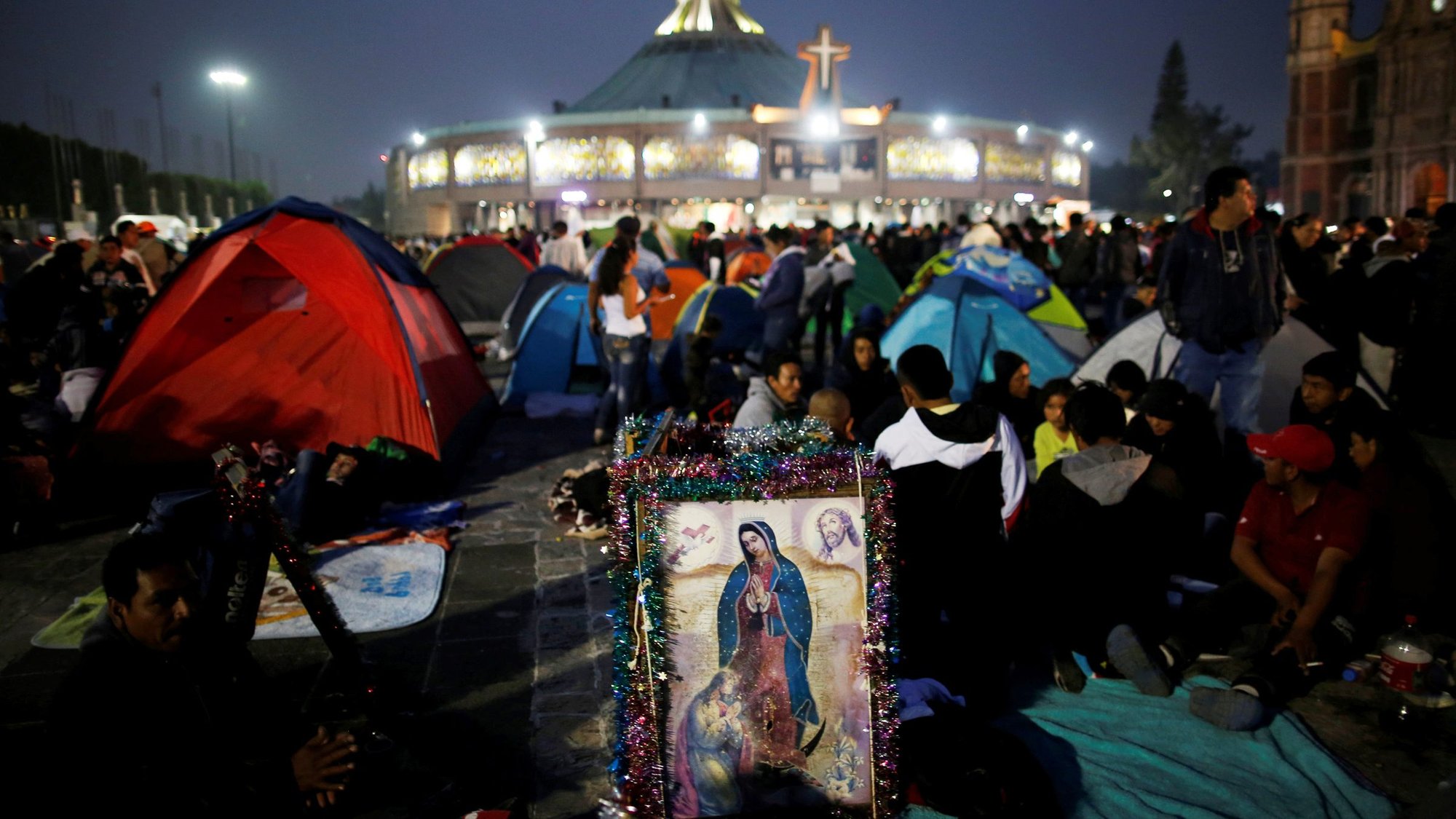 Pilgrims rest beside an image of Our Lady of Guadalupe Dec. 11, 2018, the eve of her feast day at the Basilica of Our Lady of Guadalupe in Mexico City. The Latin American bishops' council, CELAM, and the Mexican bishops' conference announced plans to consecrate Latin America and the Caribbean to Our Lady of Guadalupe on Easter, April 12, 2020. (CNS/Carlos Jasso, Reuters)
