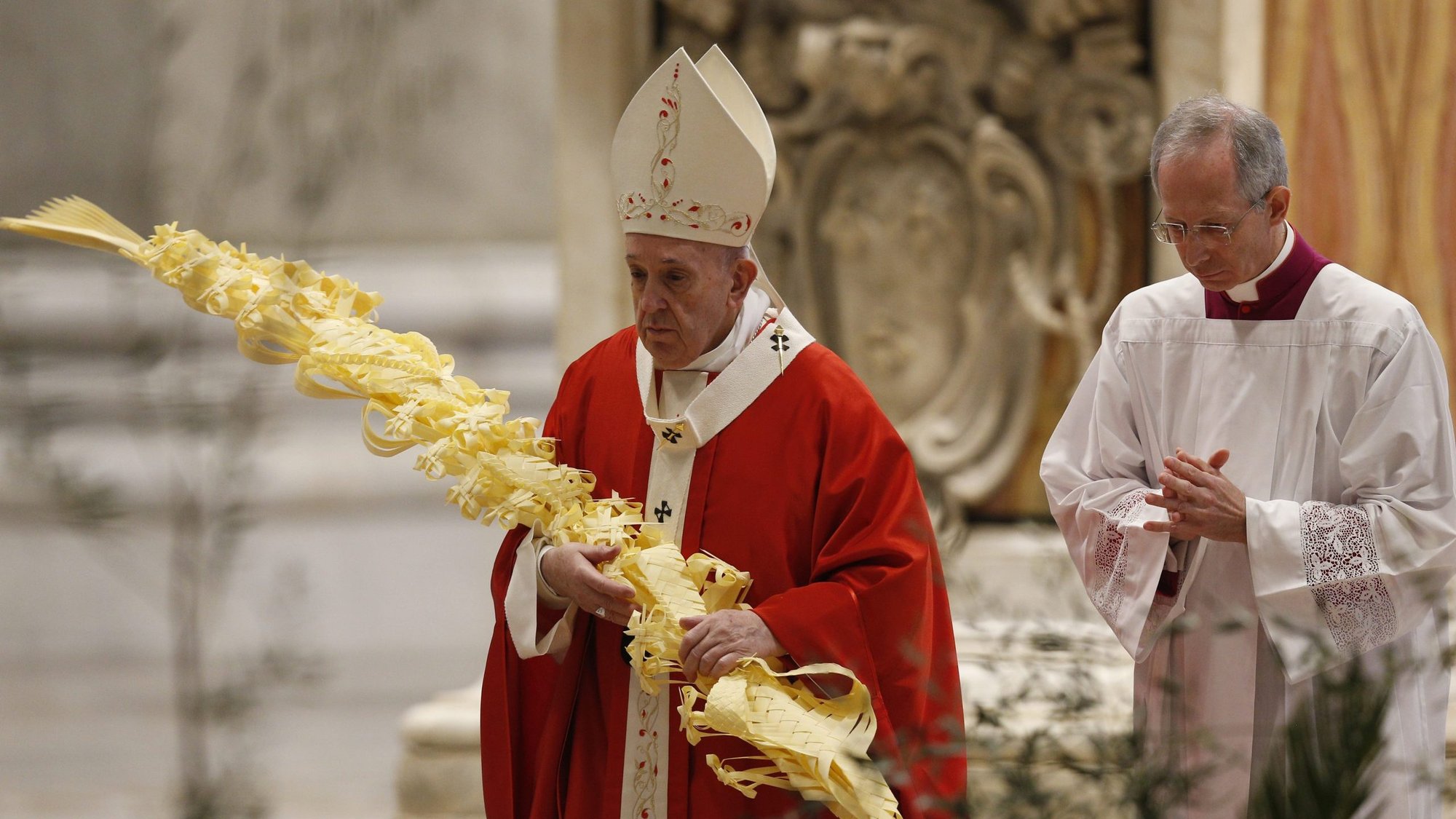 Pope Francis carries palm fronds in procession during Palm Sunday Mass in St. Peter's Basilica at the Vatican April 5, 2020. The Mass was celebrated without the presence of the public as Italy battles the coronavirus. (CNS photo/Paul Haring)