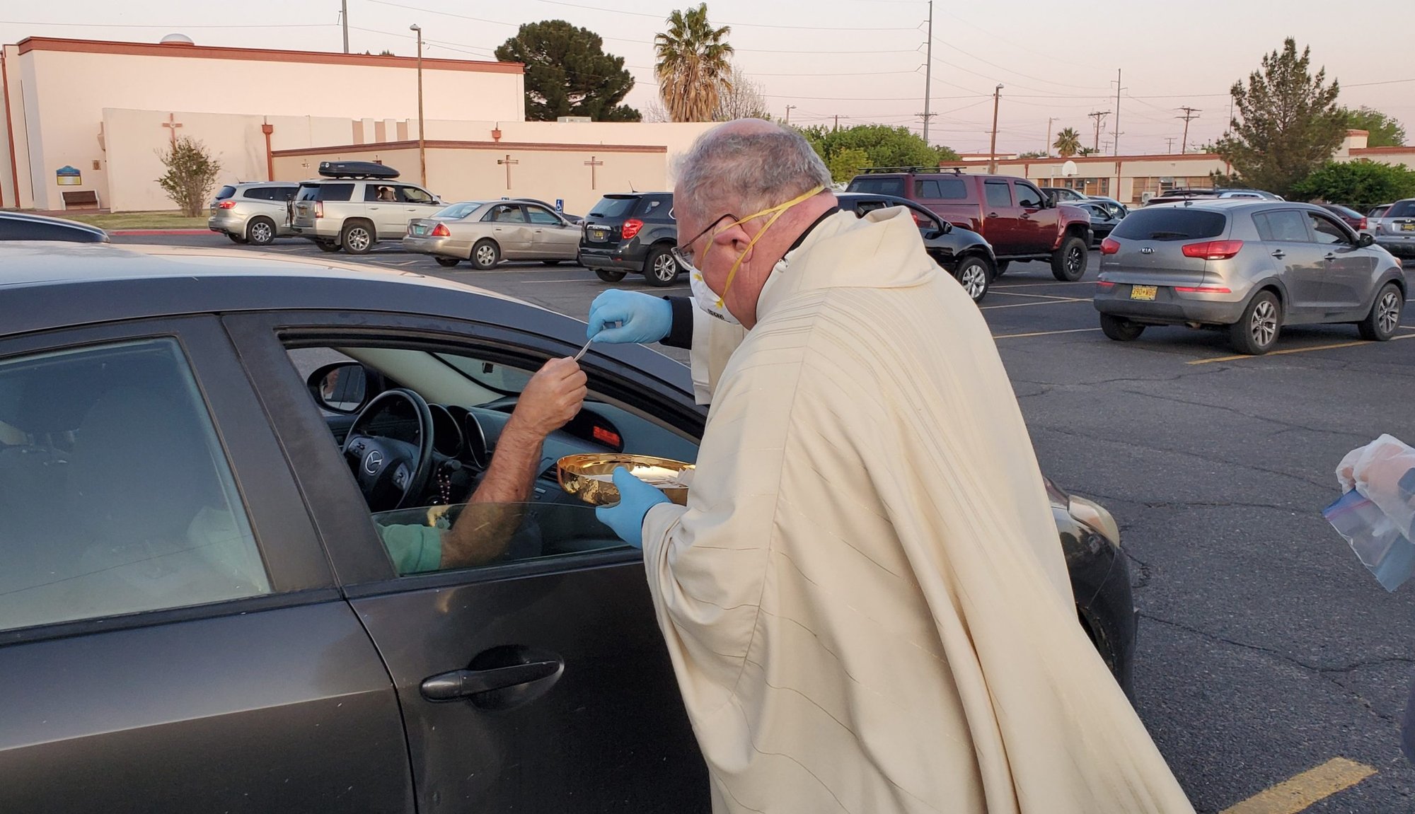 Bishop Peter Baldacchino distributes Holy Communion to faithful in their cars on Holy Thursday. (David McNamara/Diocese of Las Cruces)