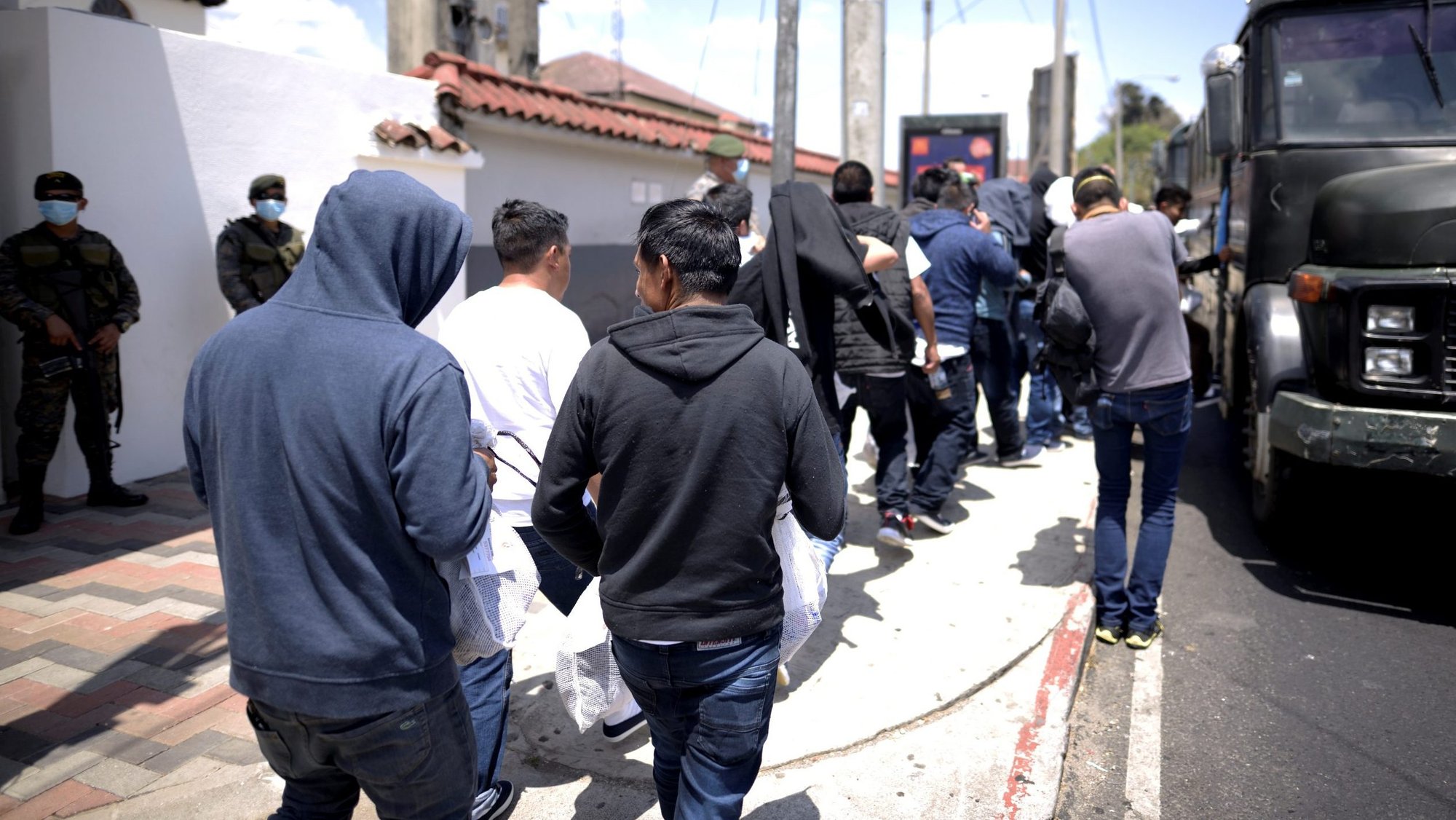 Guatemalans deported from the U.S. board a bus outside La Aurora International Airport in Guatemala City March 19, 2020. Guatemala's bishops have criticized continued deportations during the COVID-19 pandemic, saying the practice has "no sense of humanity" during a health crisis. (CNS photo/Fabricio Alonso, Reuters)