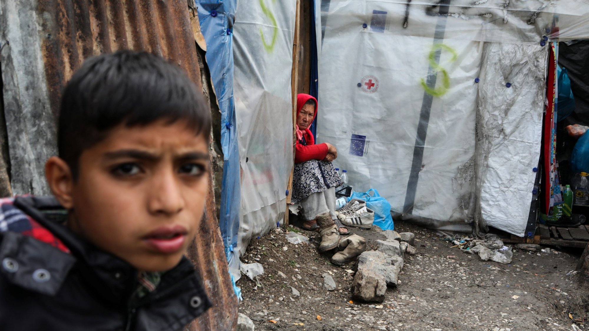 A migrant woman and child are seen outside their tent in a makeshift camp on the island of Lesbos, Greece, April 2, 2020, during the COVID-19 pandemic. (CNS photo/Elias Marcou, Reuters)