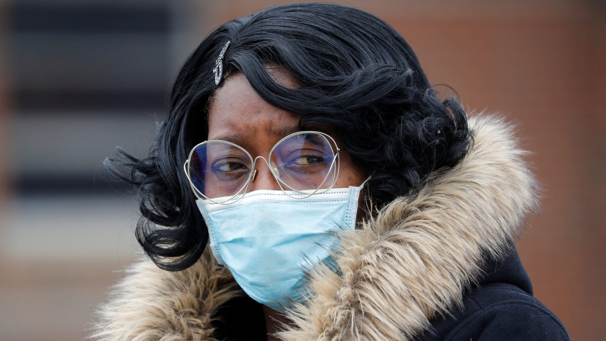 A woman in Chicago stands outside the funeral of Firefighter Edward Singleton April 22, 2020, who died from from COVID-19 symptoms. U.S. bishops issued a statement May 4 urging state and national leaders to examine the impact of the coronavirus on African American communities. (CNS photo/Shannon Stapleton, Reuters)