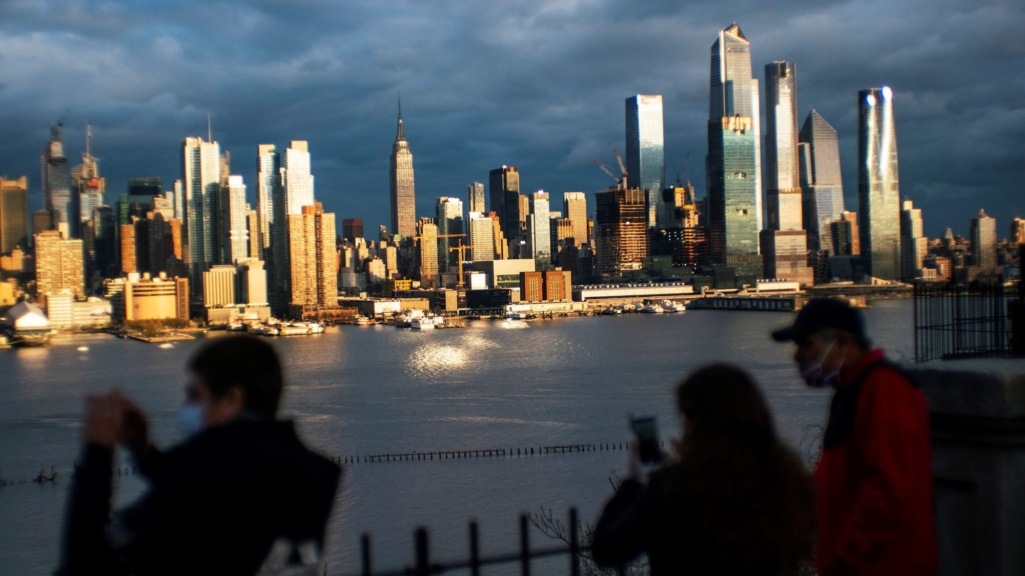 People in Weehawken, N.J., look at the New York City skyline April 18, 2020, during the coronavirus pandemic. Catholic advocates and religious communities in a May 5, 2020, letter urged Congress to address environmental justice, health care and access to safe drinking water for minority communities as part of its response to the coronavirus pandemic. (CNS photo/Eduardo Munoz, Reuters)