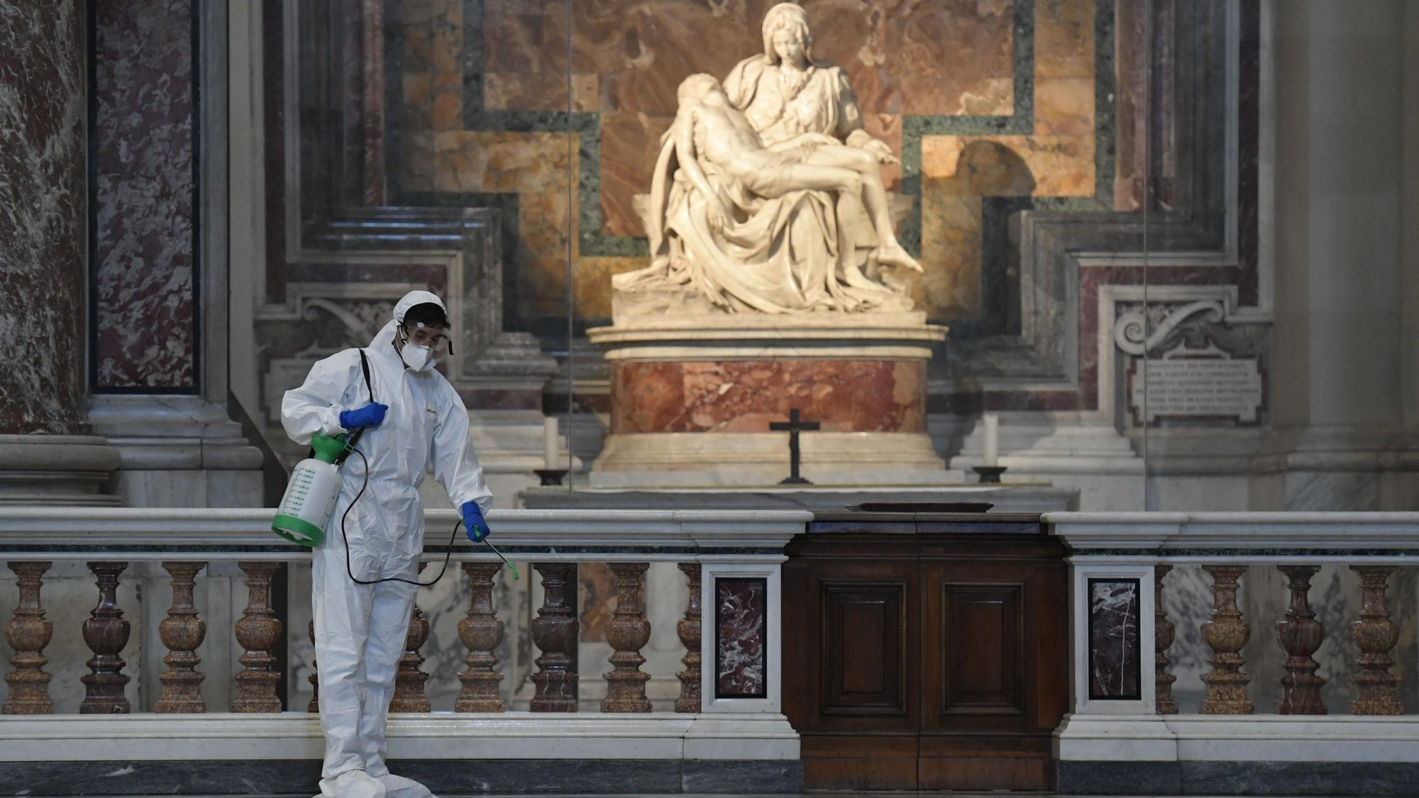 Vatican workers in protective gear sanitize various surfaces near Michelangelo's Pieta inside St. Peter's Basilica at the Vatican May 15, 2020, ahead of the resumption of Masses during the COVID-19 pandemic. (CNS photo/Vatican Media)