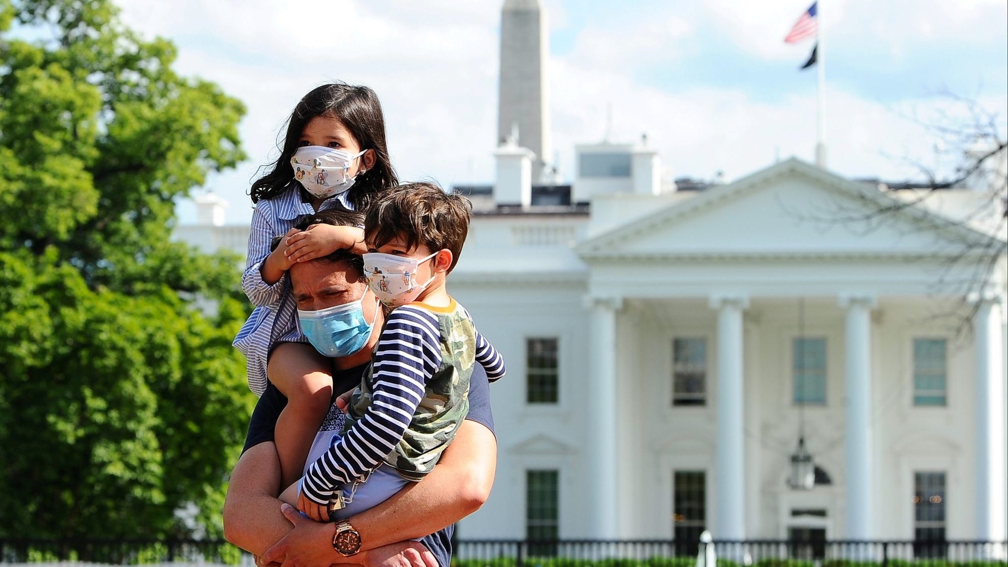 A family in Washington poses for a photo near the White House May 23, 2020, during the coronavirus pandemic. (CNS photo/Mary F. Calvert, Reuters)