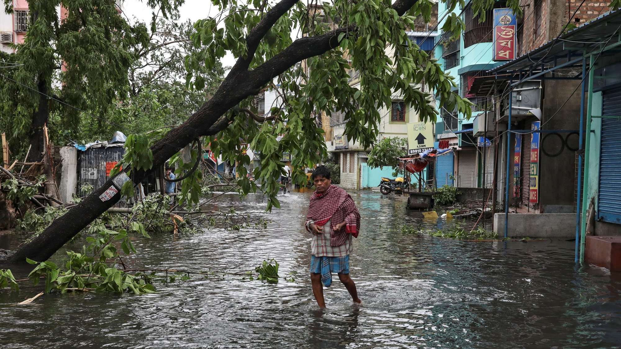 A man crosses a flooded street in Kolkata, India, May 21, 2020, after Cyclone Amphan made its landfall. Following the cyclone, incessant rain and floods have forced hundreds of thousands of people to move to safer places in eastern India's Assam state. (CNS photo/Rupak De Chowdhuri, Reuters)
