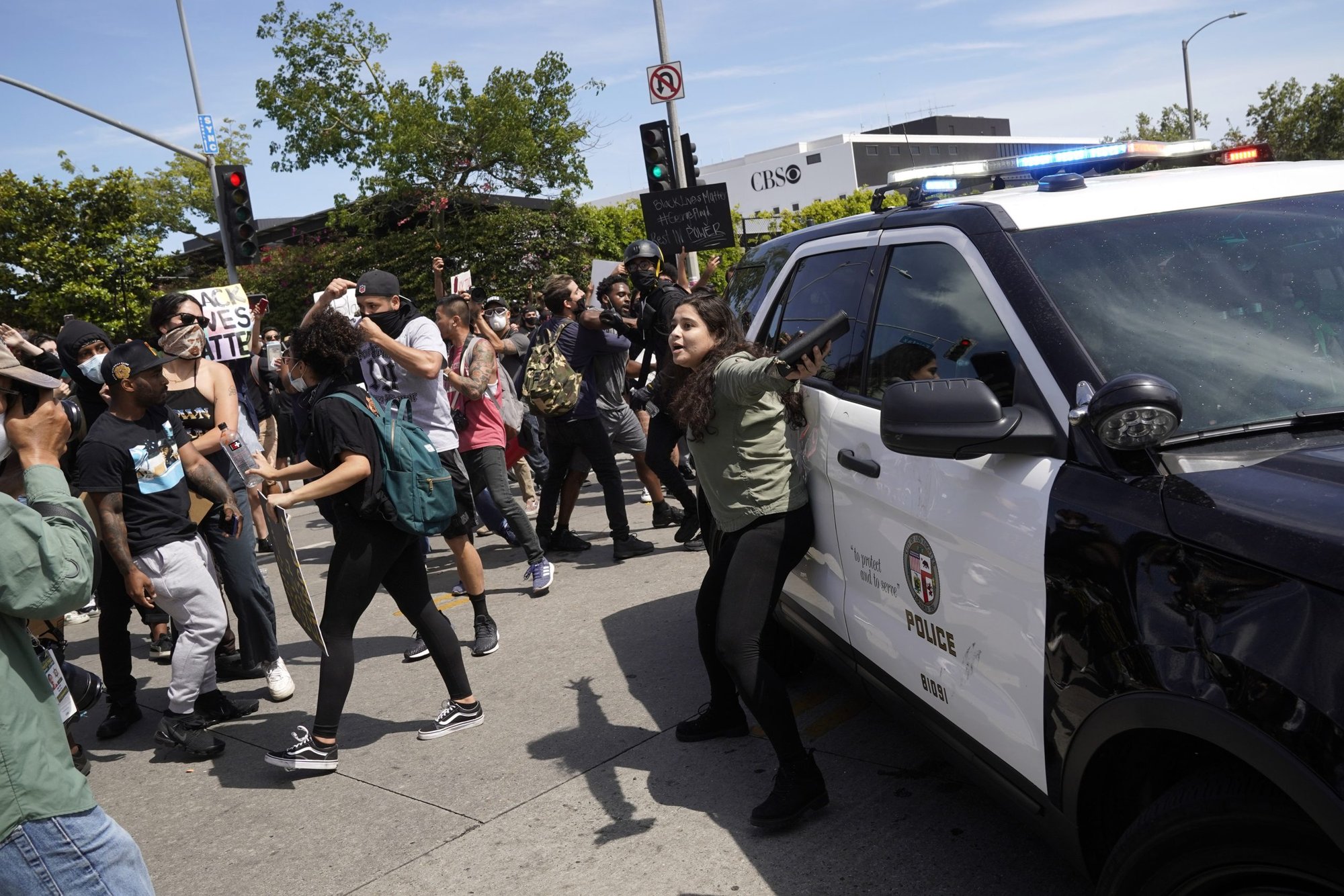 A protestor attempts to prevent others from attacking a manned police vehicle during demonstrations following the death of George Floyd on May 30, 2020 in Los Angeles, California. (Photo by Warrick Page/Getty Images)