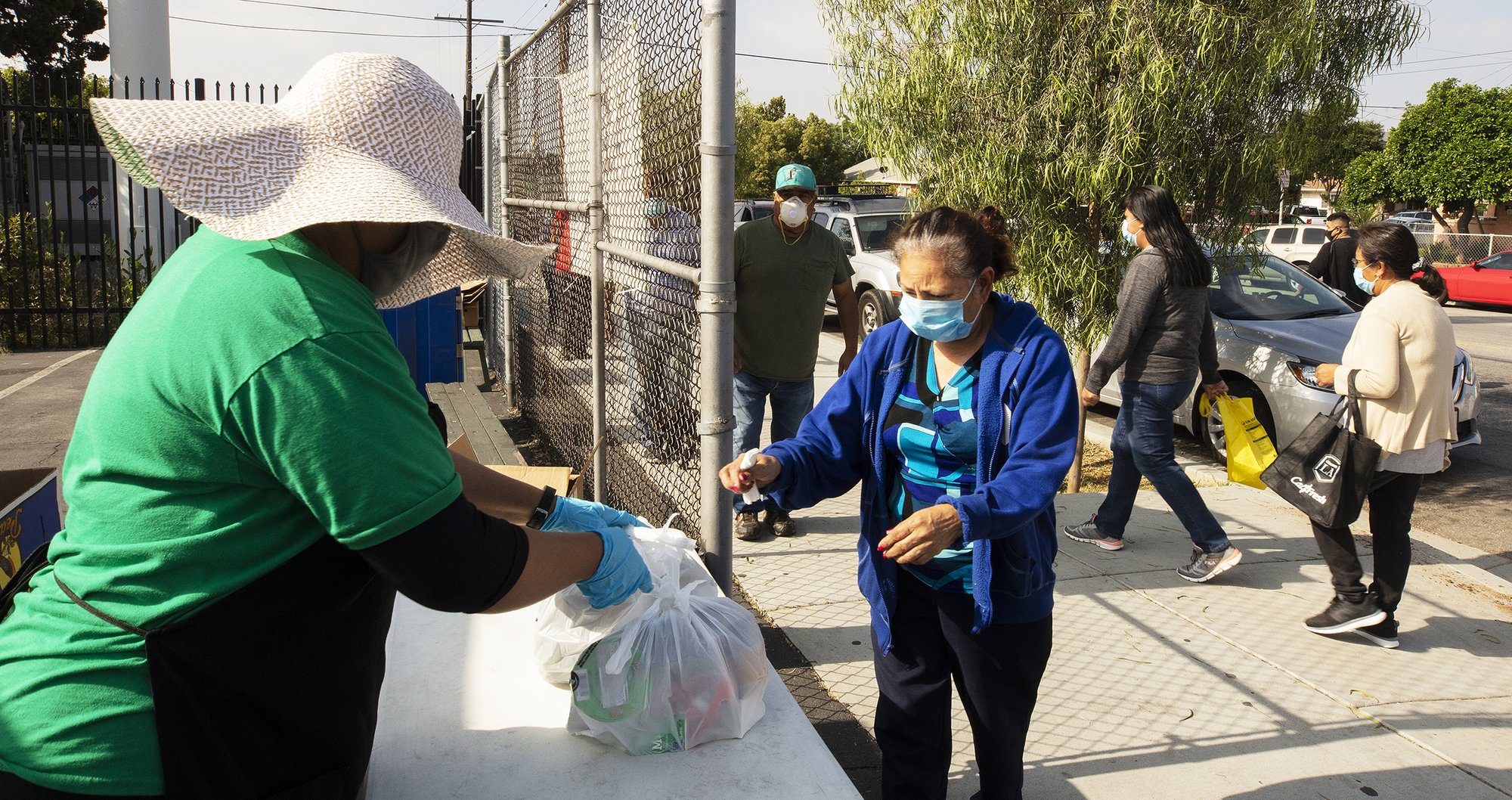 Bagged free lunches are distributed to needy families at the entrance of Our Lady of Guadalupe School in East LA. (Victor Alemán)