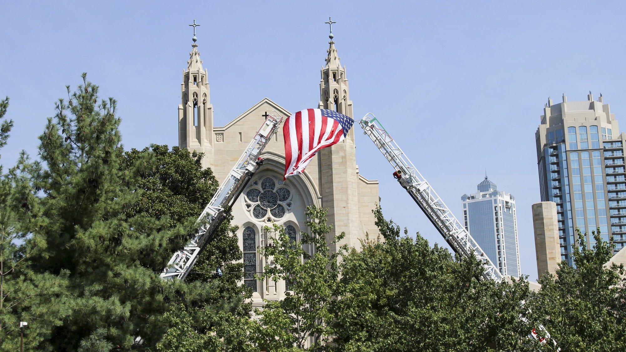 Fire rescue ladders raise the American flag outside the Cathedral of Christ the King in Atlanta where the annual Blue Mass was celebrated. (CNS photo/David Pace, Georgia Bulletin)