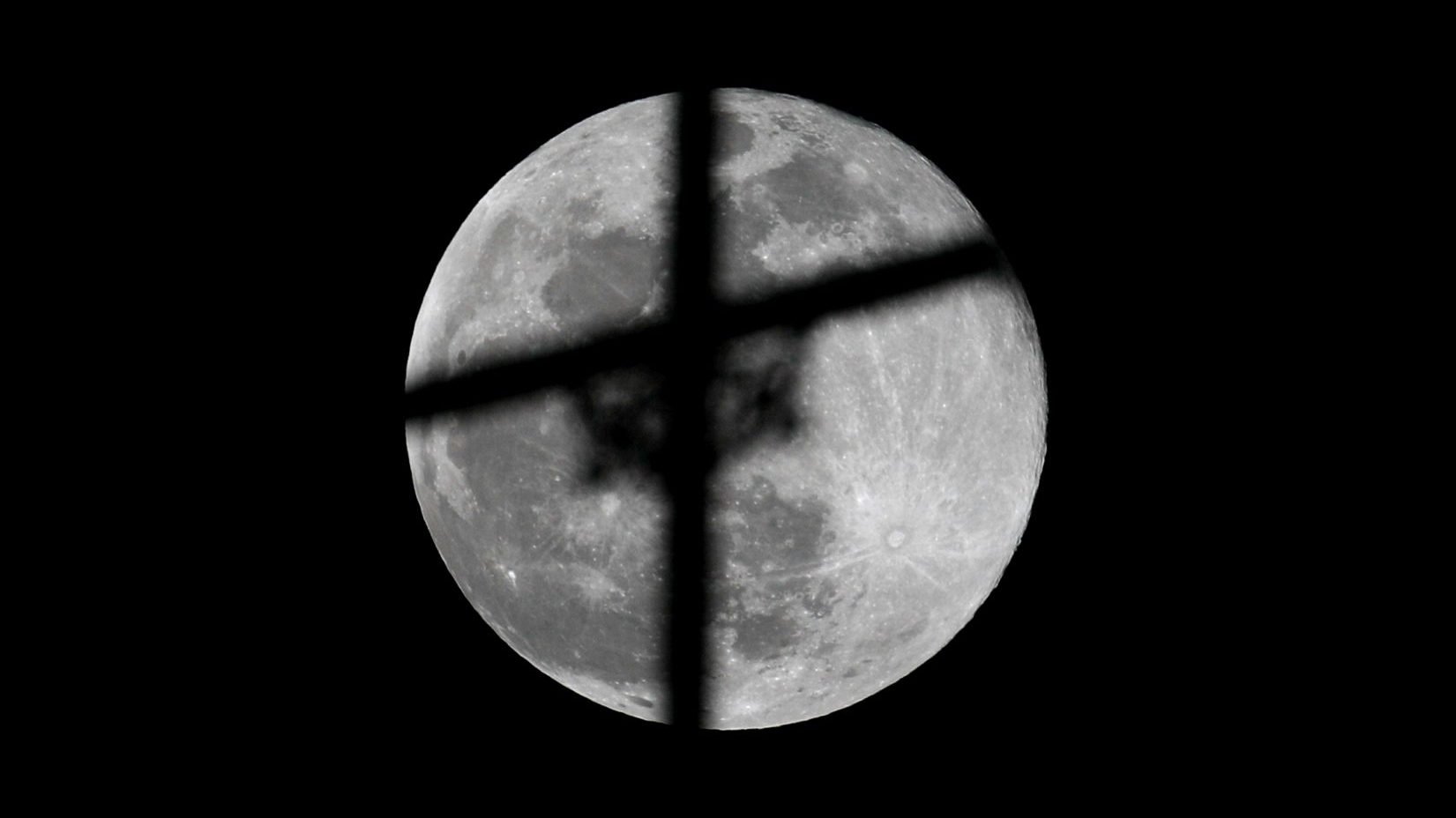 The supermoon, the biggest full moon of 2020, rises behind a cross atop a church May 7 in Karachi, Pakistan. (CNS photo/Akhtar Soomro, Reuters)