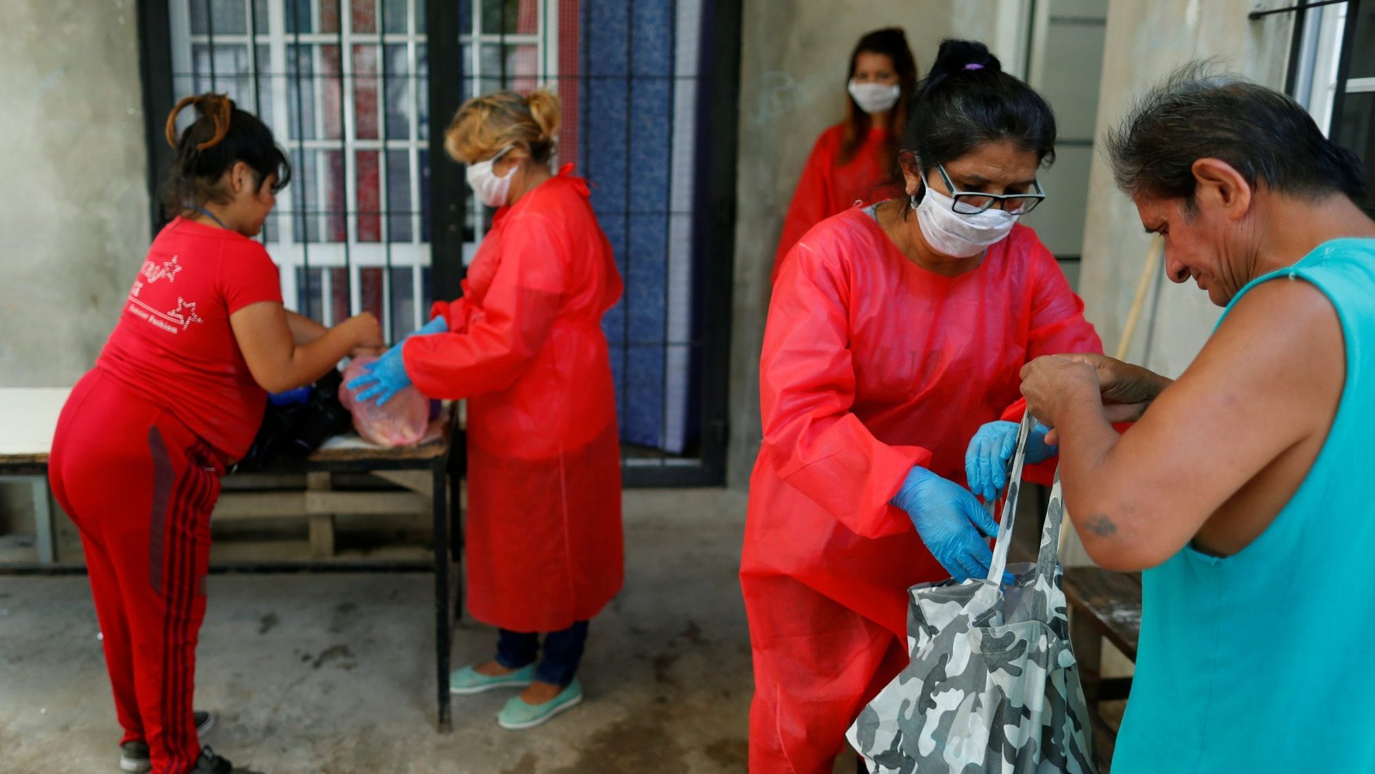 A file photo shows volunteers in protective masks giving food to low-income people at a soup kitchen in Buenos Aires, Argentina, during the COVID-19 pandemic. The Catholic Church will mark the World Day of the Poor Nov. 15. (CNS photo/Agustin Marcarian, Reuters)
