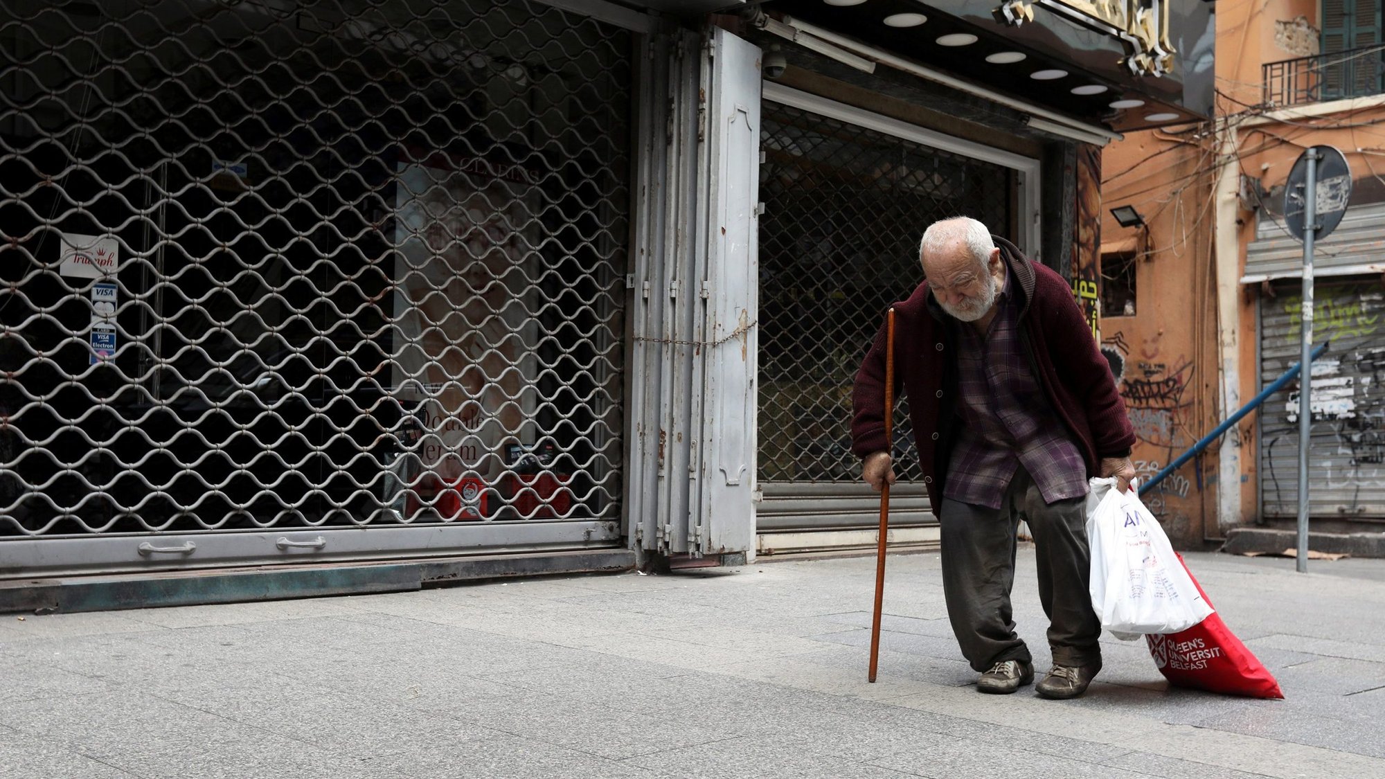 A file photo shows a homeless man walking past closed shops in Beirut during the COVID-19 pandemic. (CNS photo/Mohamed Azakir, Reuters)