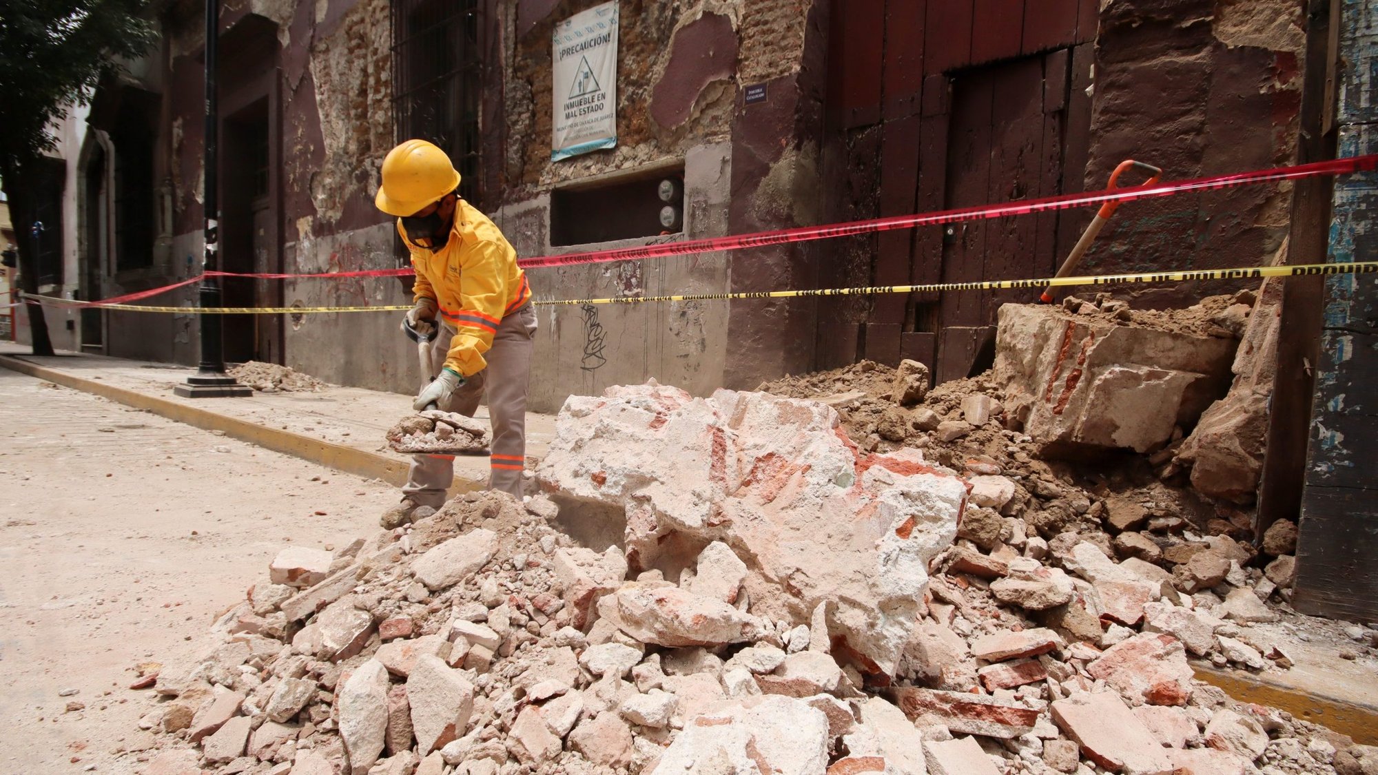 A worker clears debris from a building in Oaxaca, Mexico, June 23, 2020, following an earthquake. The quake struck as COVID-19 cases are increasing and people are wary of going to the hospital. (CNS photo/Jorge Luis Plata, Reuters)
