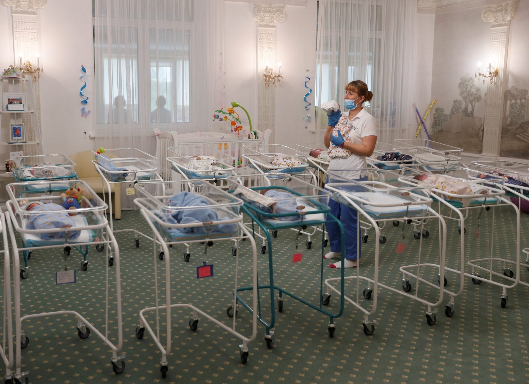 A nurse and newborns in the Hotel Venice, which is owned by BioTexCom, a surrogacy agency in Kyiv, Ukraine, May 14. (Catholic News Service/Gleb Garanich, Reuters)