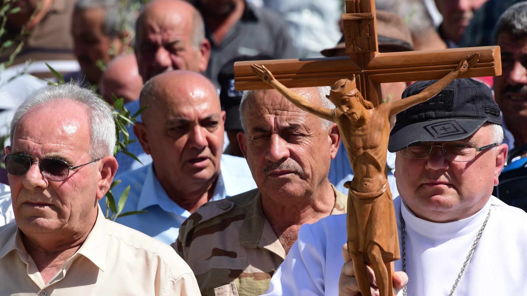 Father Andrzej Halemba is seen in a 2017 file photo carrying a crucifix during a procession of the Christians in Qaraqosh, Iraq. (CNS photo/courtesy Aid to the Church in Need)