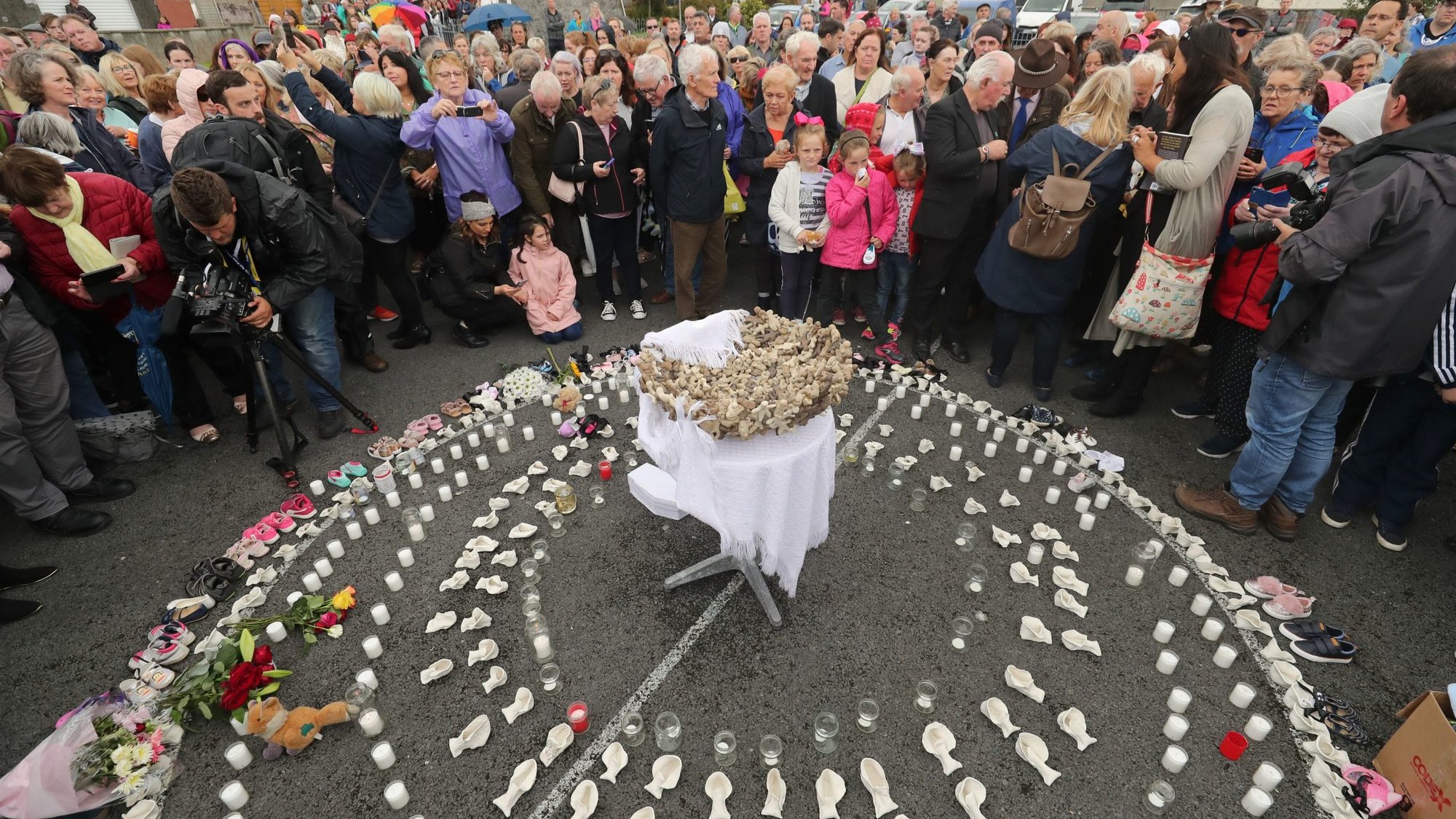 People gather to protest at the site of the former state-funded, Catholic-run home for unmarried mothers in Tuam, Ireland -- where a mass grave of 796 babies was uncovered -- in this 2018 photo. The Vatican ambassador to Ireland has backed the idea that the babies should be reburied in consecrated ground. (CNS photo/Niall Carson, Reuters)